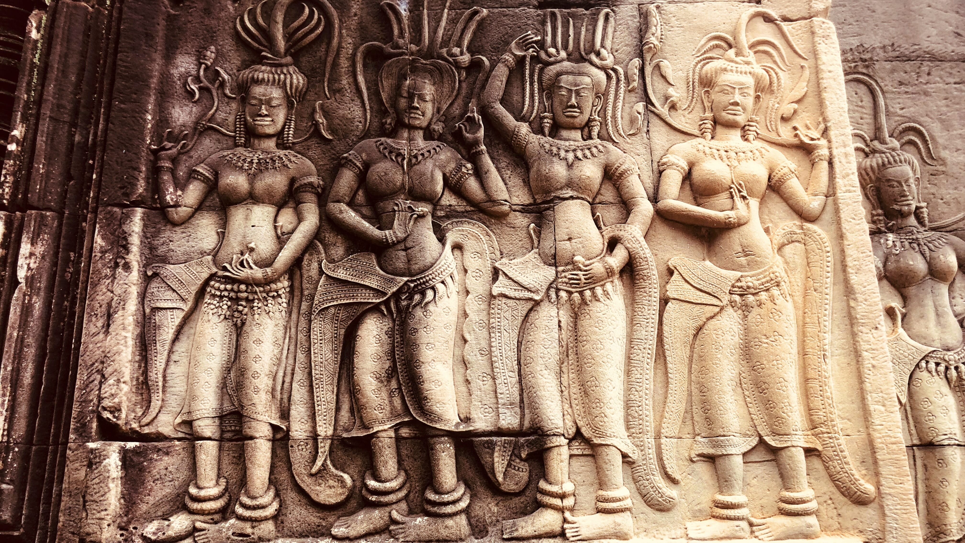 Stone bas-relief carvings of apsara dancers at Angkor Wat in Cambodia, showing intricate detail and traditional Khmer artistry during a five-day Cambodia itinerary.
