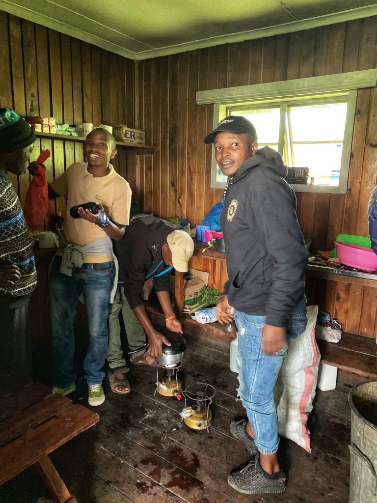 Porters preparing meals inside Anabas Mount Lodge kitchen during Mount Kenya hike.