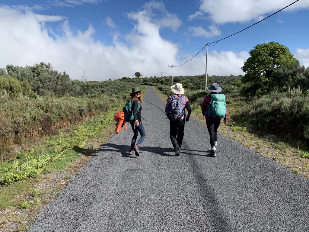 Trekker smiling on the road out of Mount Kenya National Park at the end of the hike.
