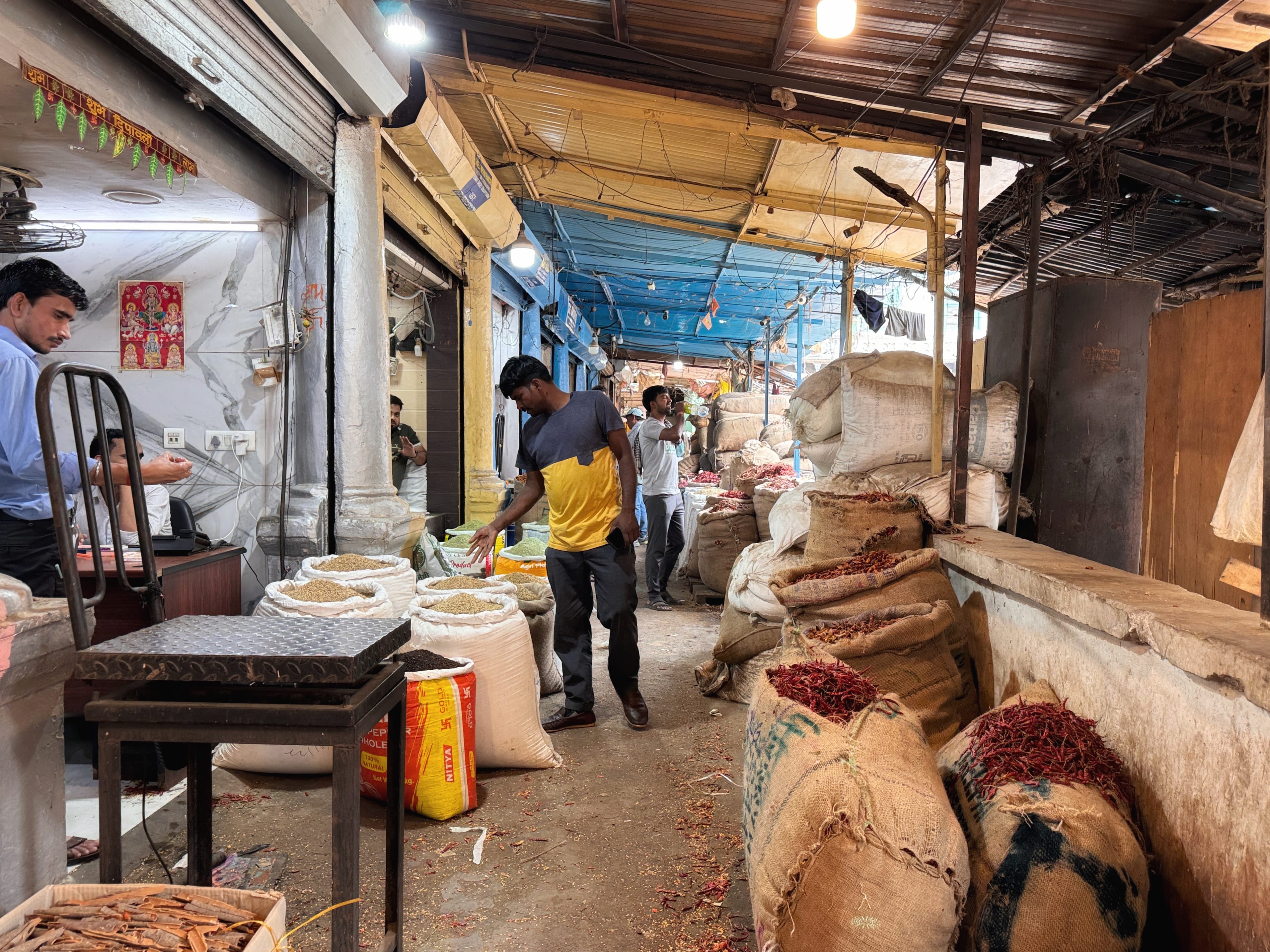 Men sorting and selling spices from burlap sacks in Khari Baoli market, Old Delhi