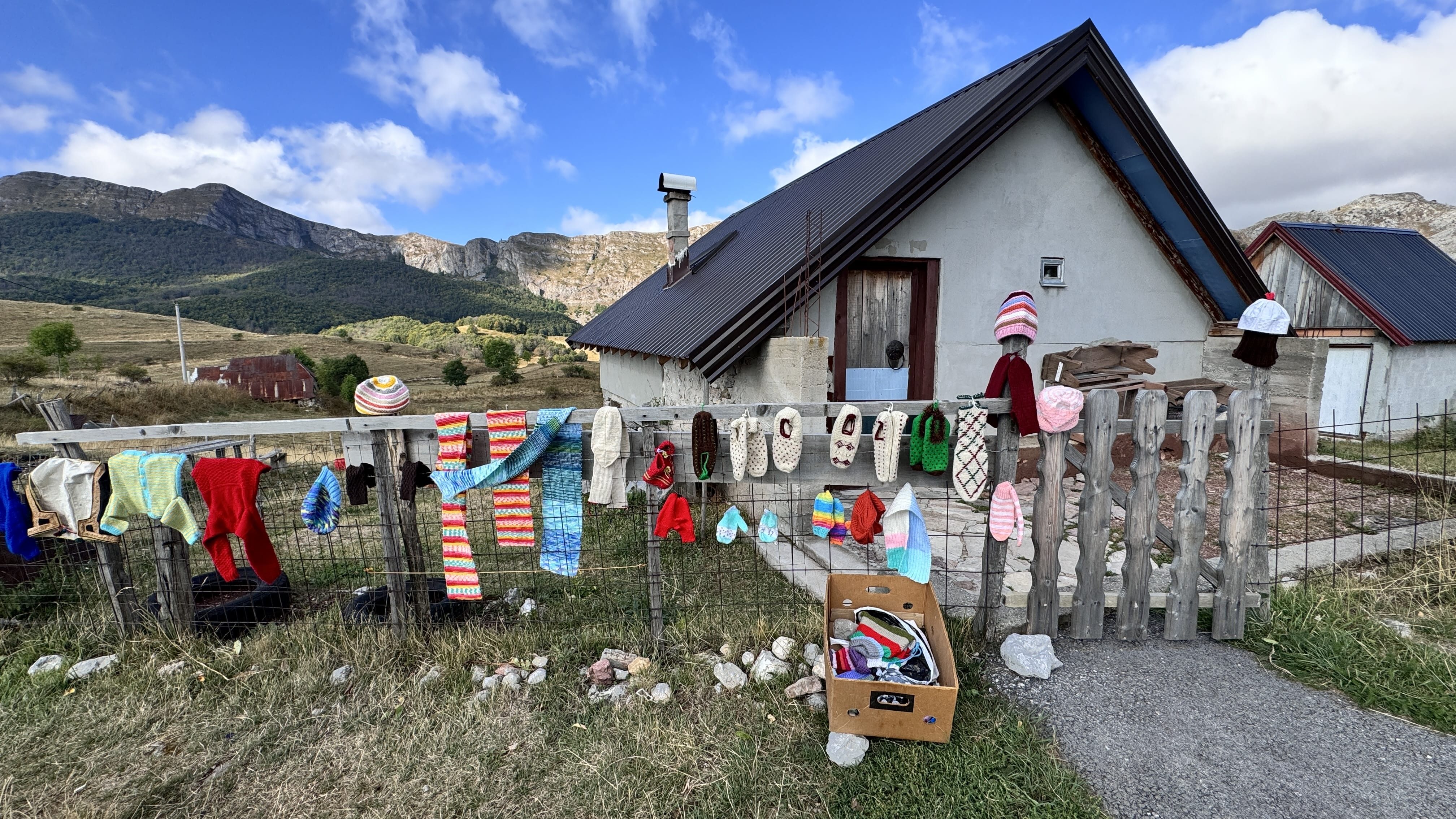 Handmade knitwear displayed on a wooden fence in Lukomir village, Bosnia and Herzegovina