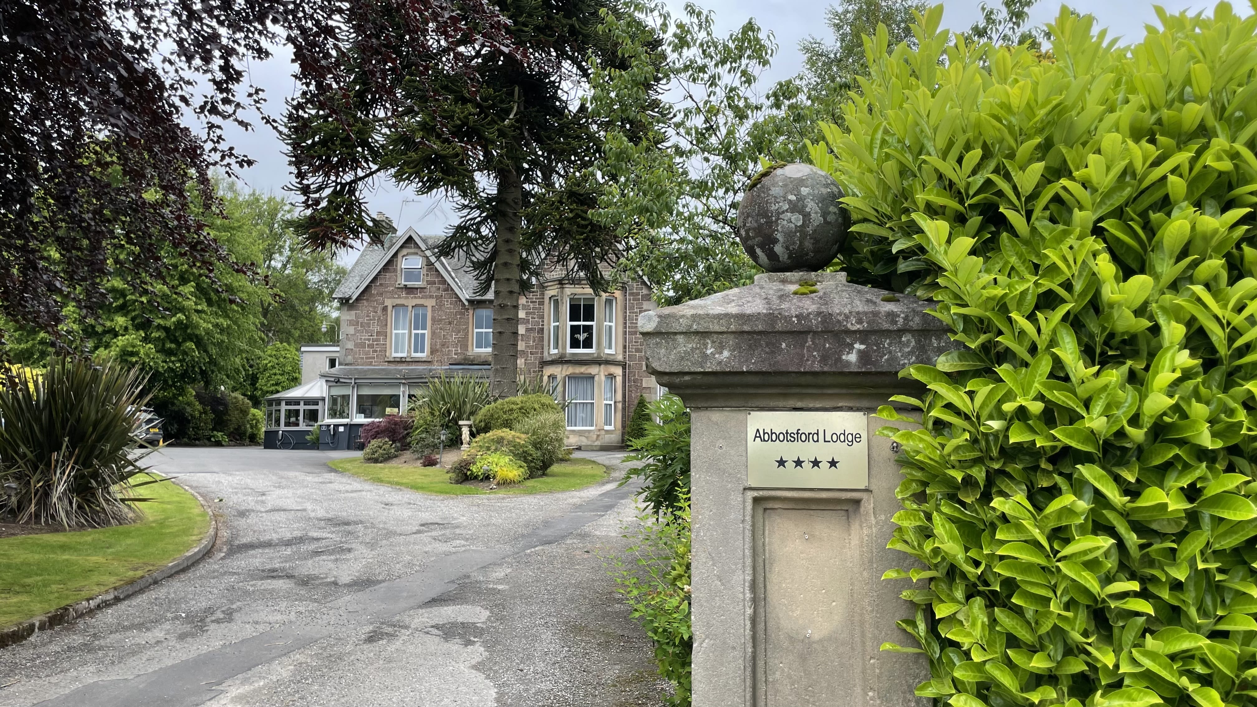 Abbotsford Lodge in Callander, a stone guesthouse with manicured gardens and a four-star plaque at the entrance.