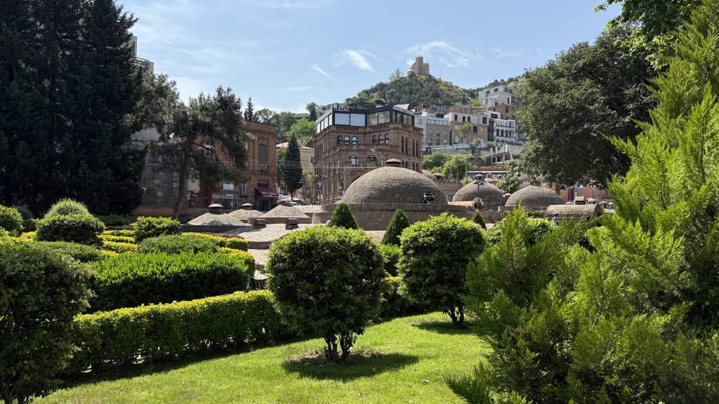 Tbilisi’s Sulfer Baths in the Abanotubani district showing the domed roofs of sulfur baths surrounded by gardens and greenery.