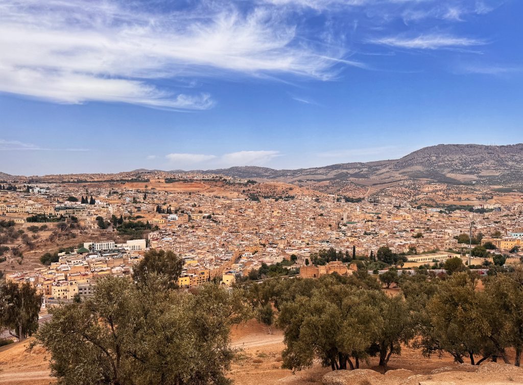 Panoramic view of Fes, Morocco, taken from Borj Sud fortress, showing a dense cityscape against a backdrop of rolling hills, captured during 2 Days in Fes.