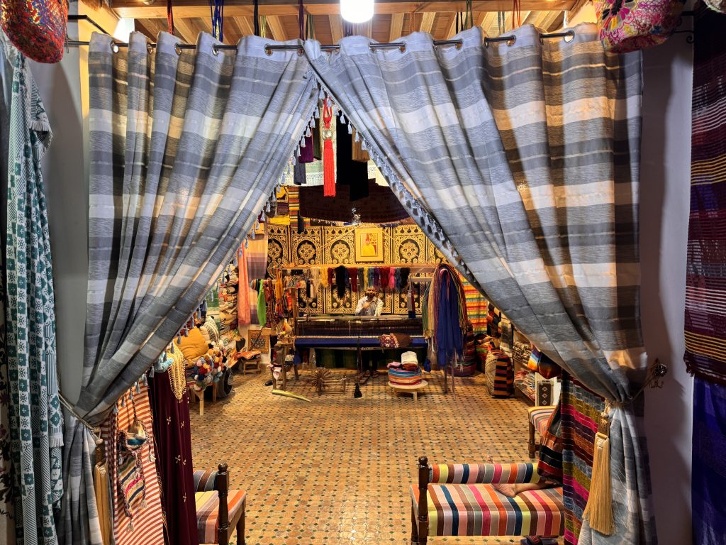 View into a Moroccan textile and weaving shop through striped curtains, taken during 2 Days in Fes.