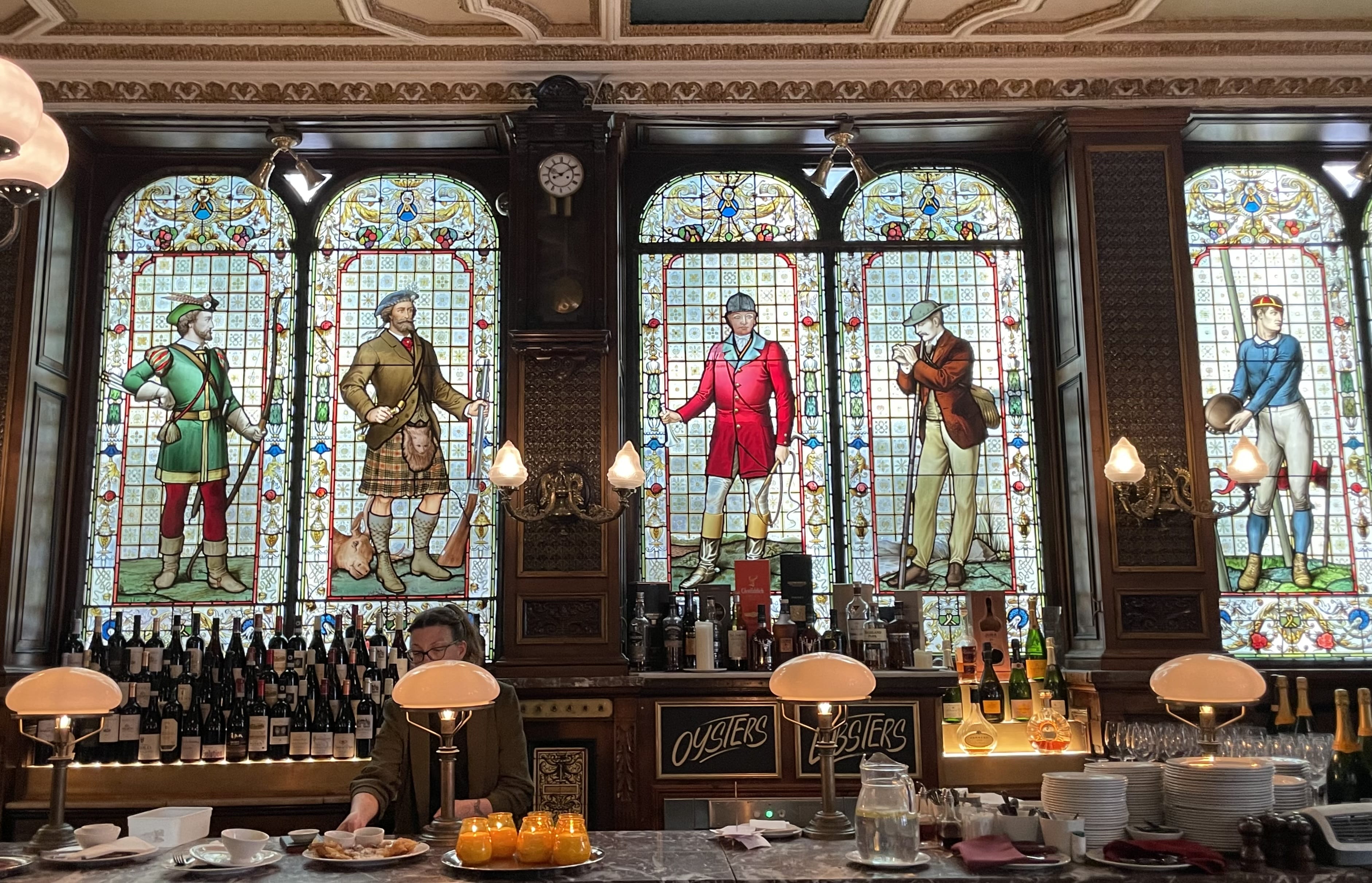Stained glass windows depicting Scottish figures inside a historic pub in Edinburgh, part of 4 days in Edinburgh itinerary.
