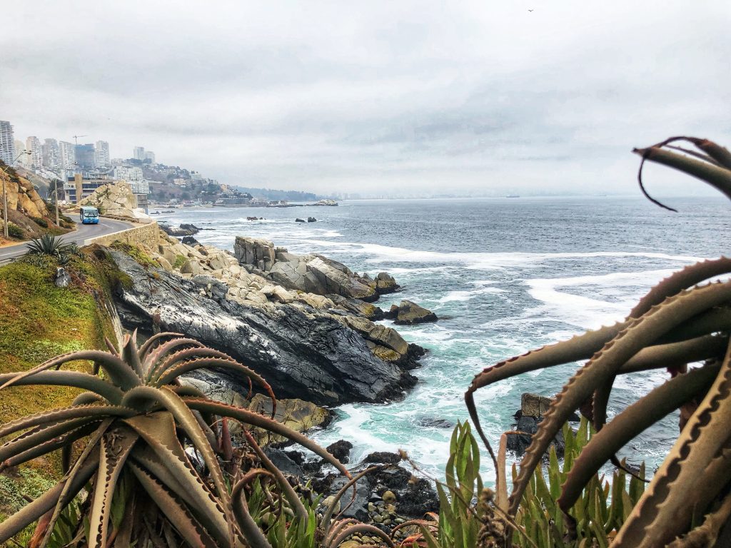 4 Days in Santiago – rugged coastline of Concón with waves crashing against the rocks and city buildings in the distance.