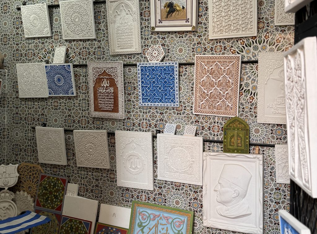 Decorative plaster and tilework panels for sale in the Marrakech medina, showcasing Islamic geometric and calligraphic designs – 2 Days in Marrakech travel blog.