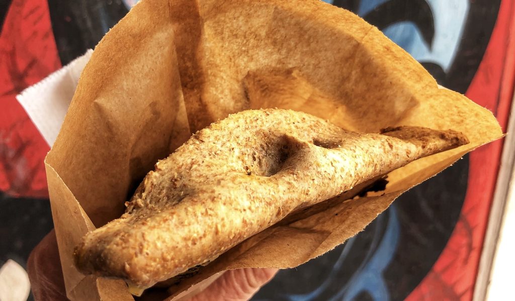 Vegetarian empanada in a paper sleeve, enjoyed in Valparaíso on a street food stop — 4 Days in Santiago, Chile.