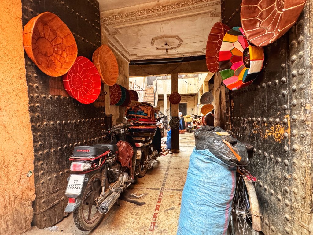 Leather poufs and stools in bright colors hanging around the entrance of a Marrakech shop—two days in Marrakech .