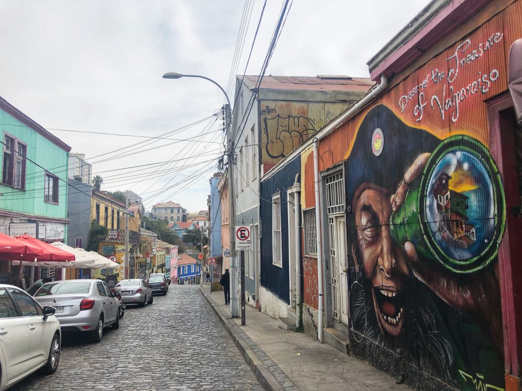 Pirate-themed mural on a street in Valparaíso, with cobblestone streets and colorful houses — 4 Days in Santiago, Chile.