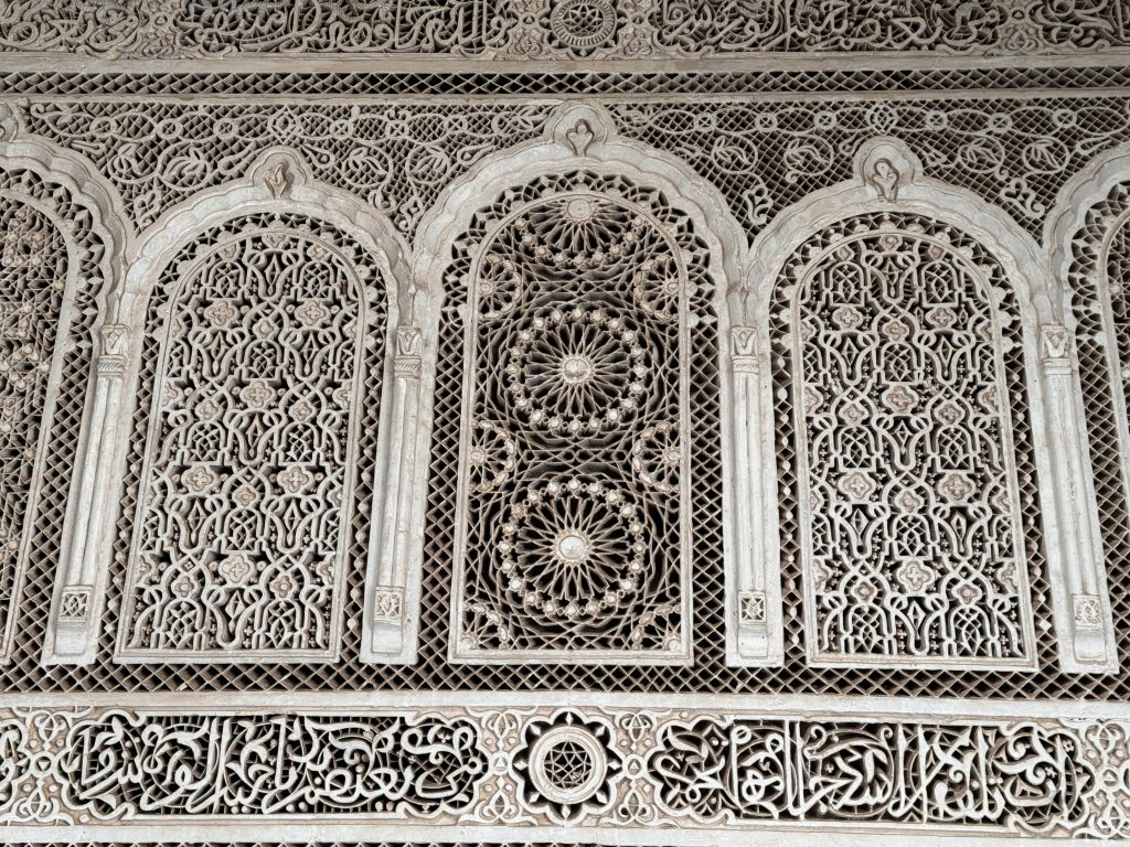 Intricately carved stucco panels with Arabic calligraphy and geometric designs inside Bahia Palace, Marrakech – 2 Days in Marrakech.