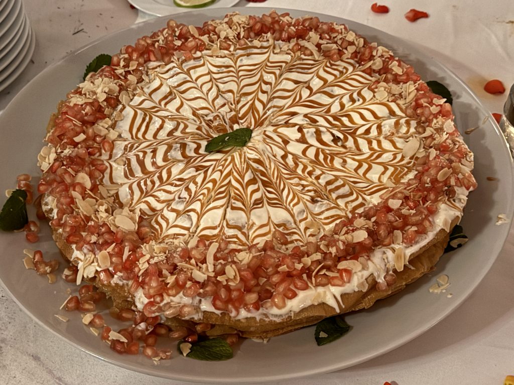 Moroccan dessert topped with cream, caramel drizzle, almonds, and pomegranate seeds – 2 days in Marrakech.