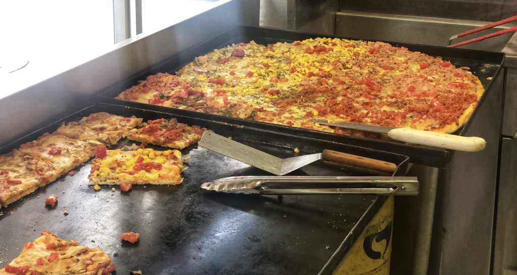 Traditional Chilean pizza with toppings like tomato and corn sold by the slice in Santiago – 4 days in Santiago.