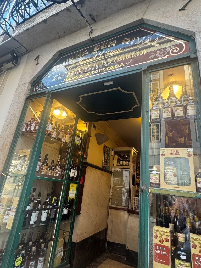 Entrance of Ginjinha Sem Rival in Lisbon, a historic cherry liqueur bar with bottles displayed in glass cases and vintage signage above the doorway —5 Days in Lisbon