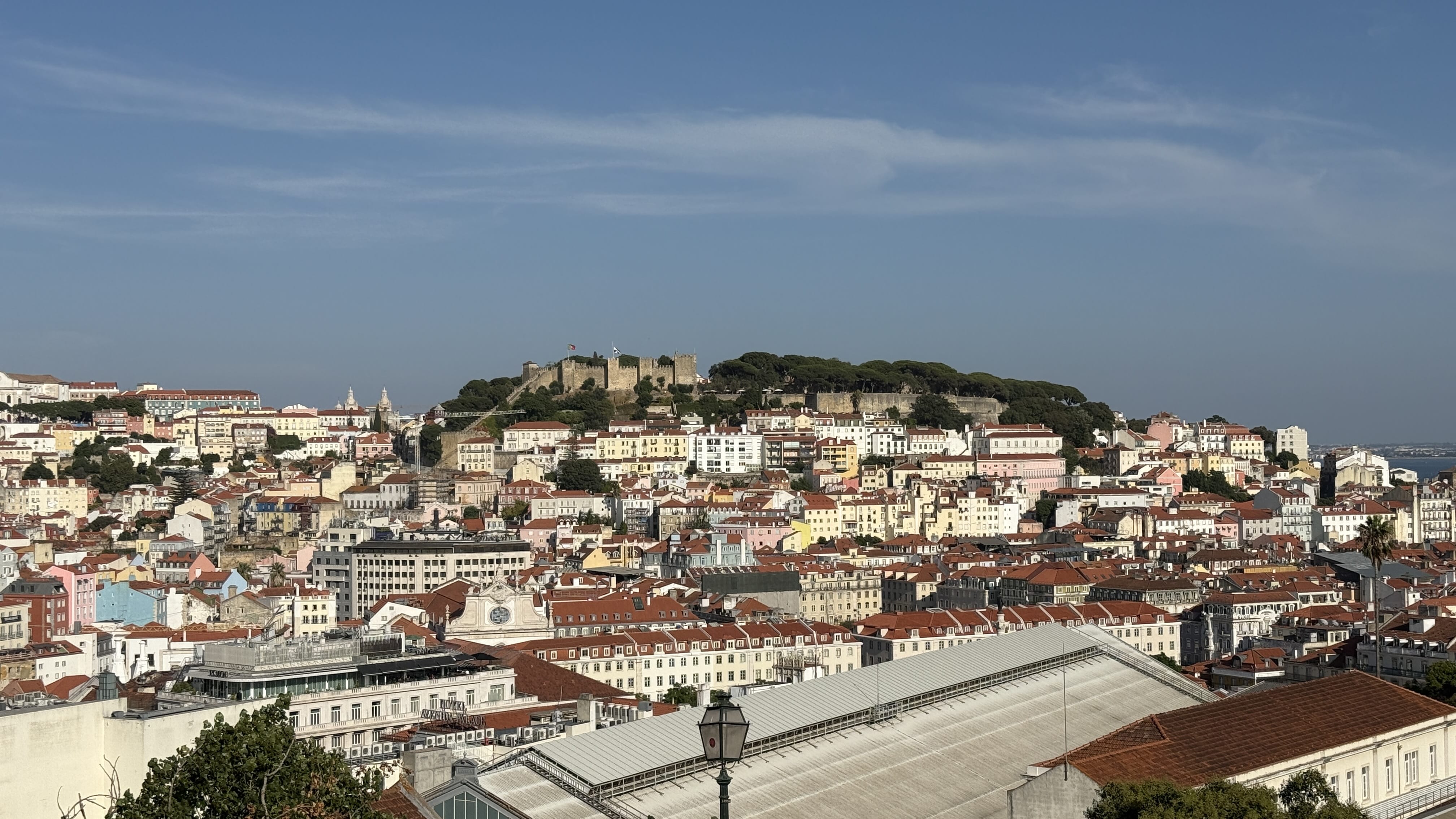 View of São Jorge Castle on the hilltop surrounded by colorful houses and red-tiled roofs in Lisbon, Portugal —5 Days in Lisbon