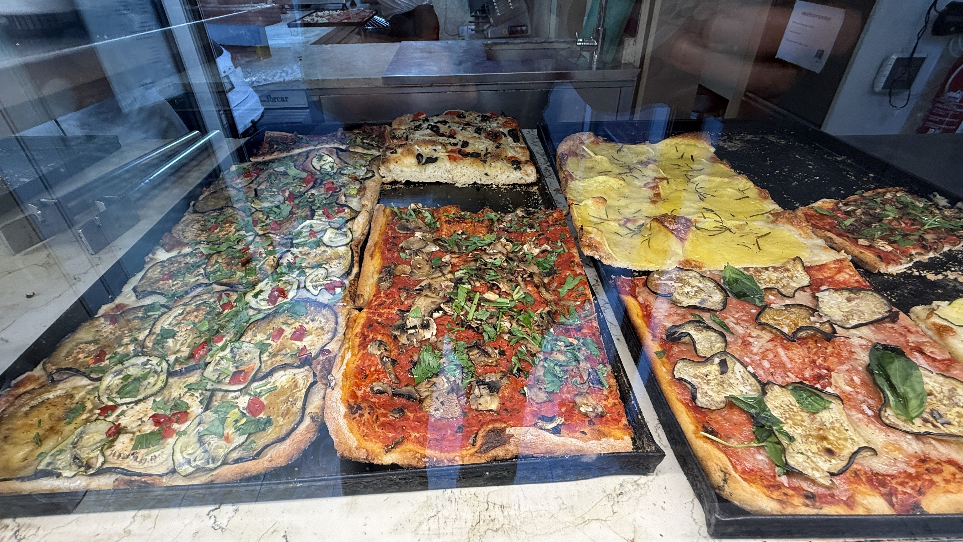 Trays of Roman-style pizza by the slice at La Pizza di Nanna in Lisbon, a foodie stop featured in Somebody Feed Phil and part of my 5 days in Lisbon itinerary.