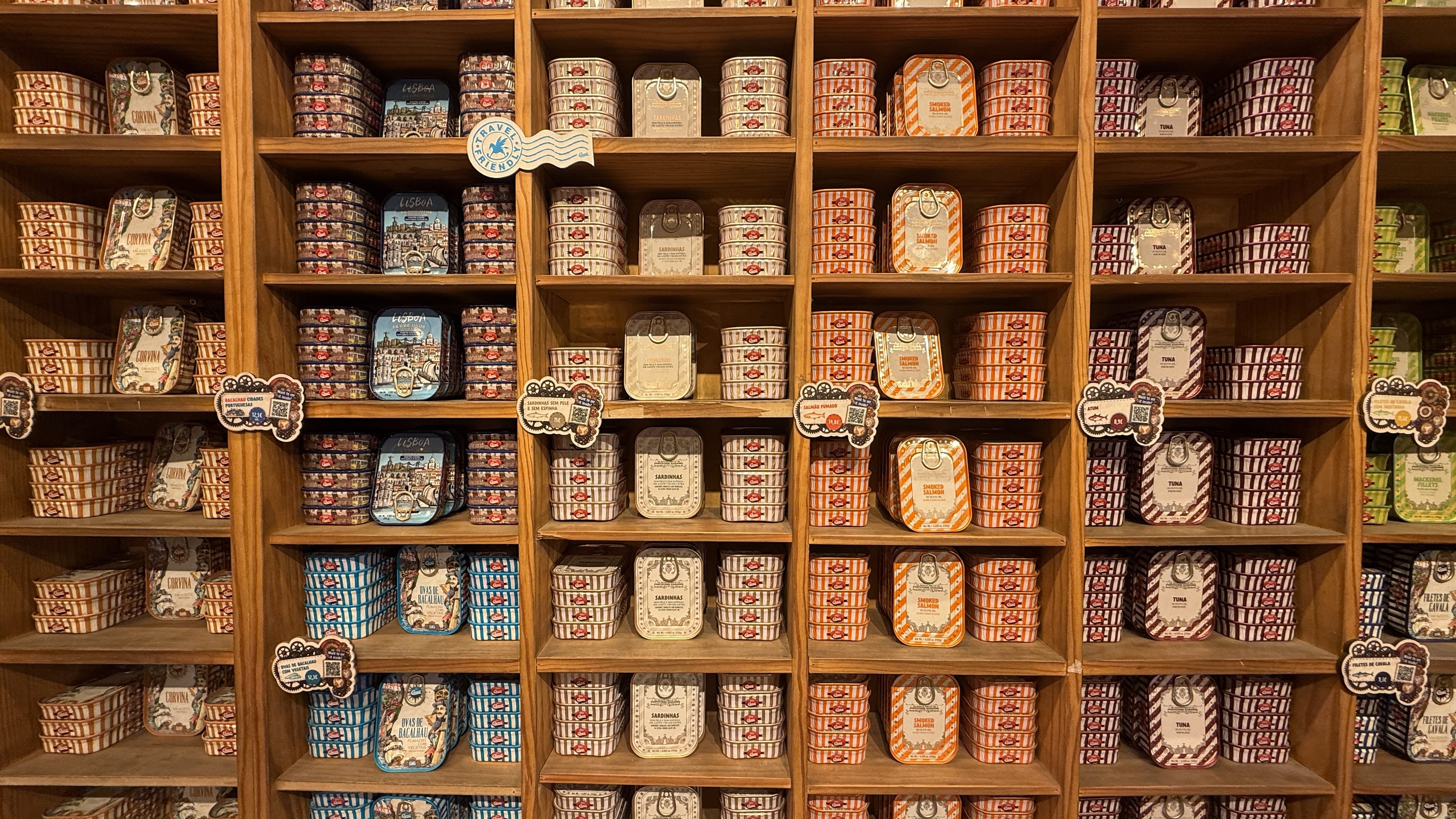 Colorful tins of sardines and tuna stacked on wooden shelves inside a specialty canned fish shop in Lisbon, Portugal—5 Days in Lisbon