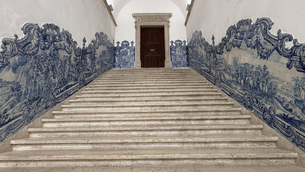 Grand staircase lined with blue-and-white azulejo tiles inside the Monastery of São Vicente de Fora in Lisbon, Portugal.