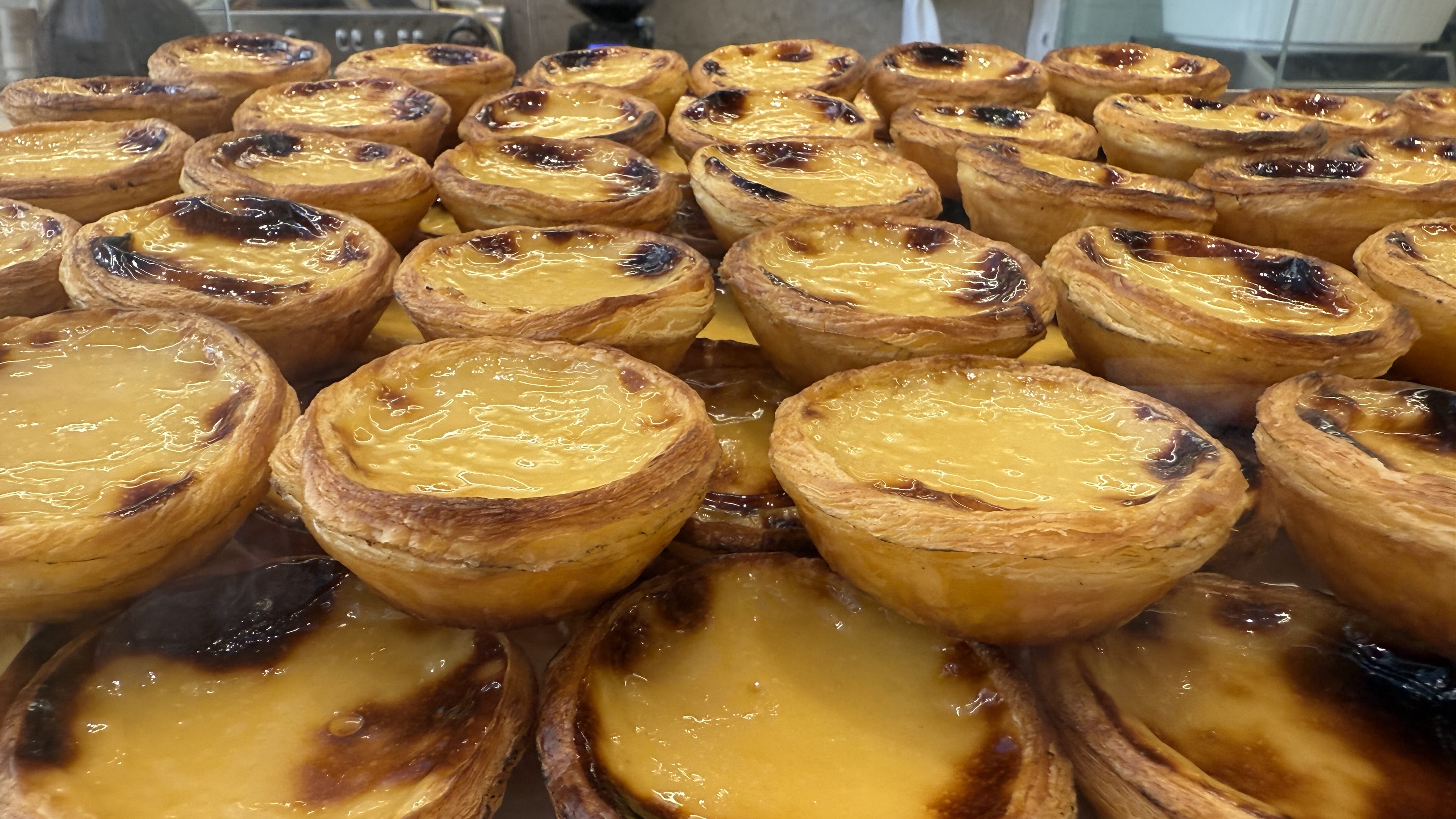 Close-up of golden Portuguese custard tarts, pastéis de nata, freshly baked at Manteigaria in Lisbon.