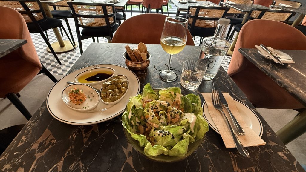 Vegan meal with olives, bread, salad, and a glass of white wine at Vegan Project restaurant —5 Days in Lisbon