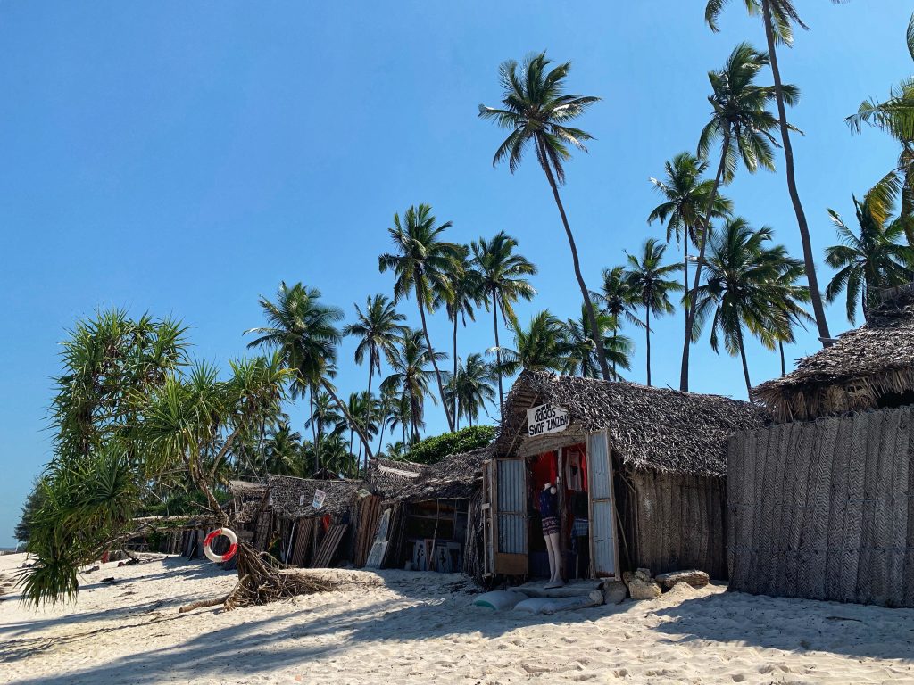 shop labeled “Adidas Shop Zanzibar” made of palm fronds and corrugated metal on the beach—3 days in Zanzibar.