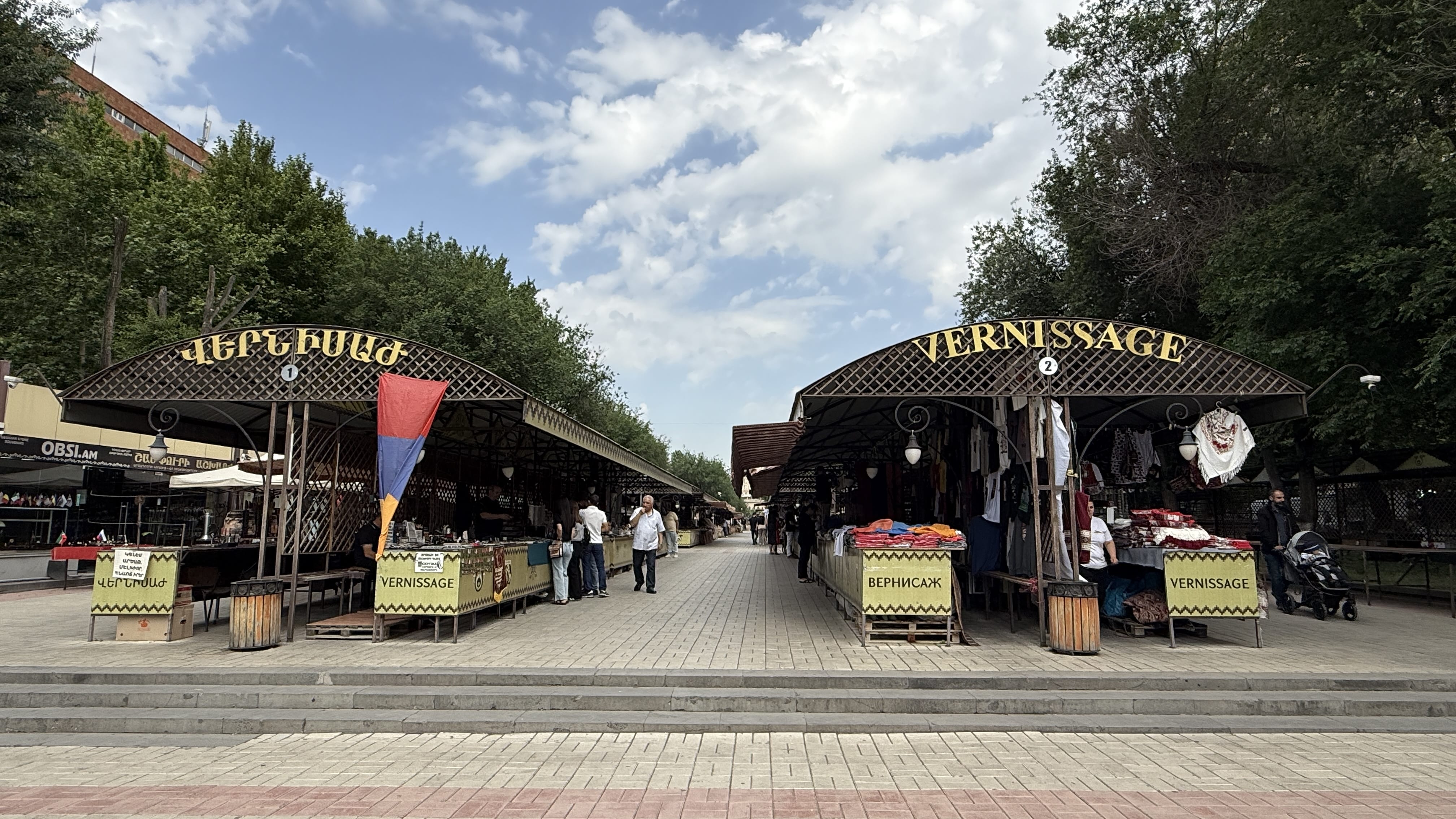Entrance to Vernissage Market in Yerevan with Armenian flags and stalls selling crafts – 24 Hours in Yerevan.