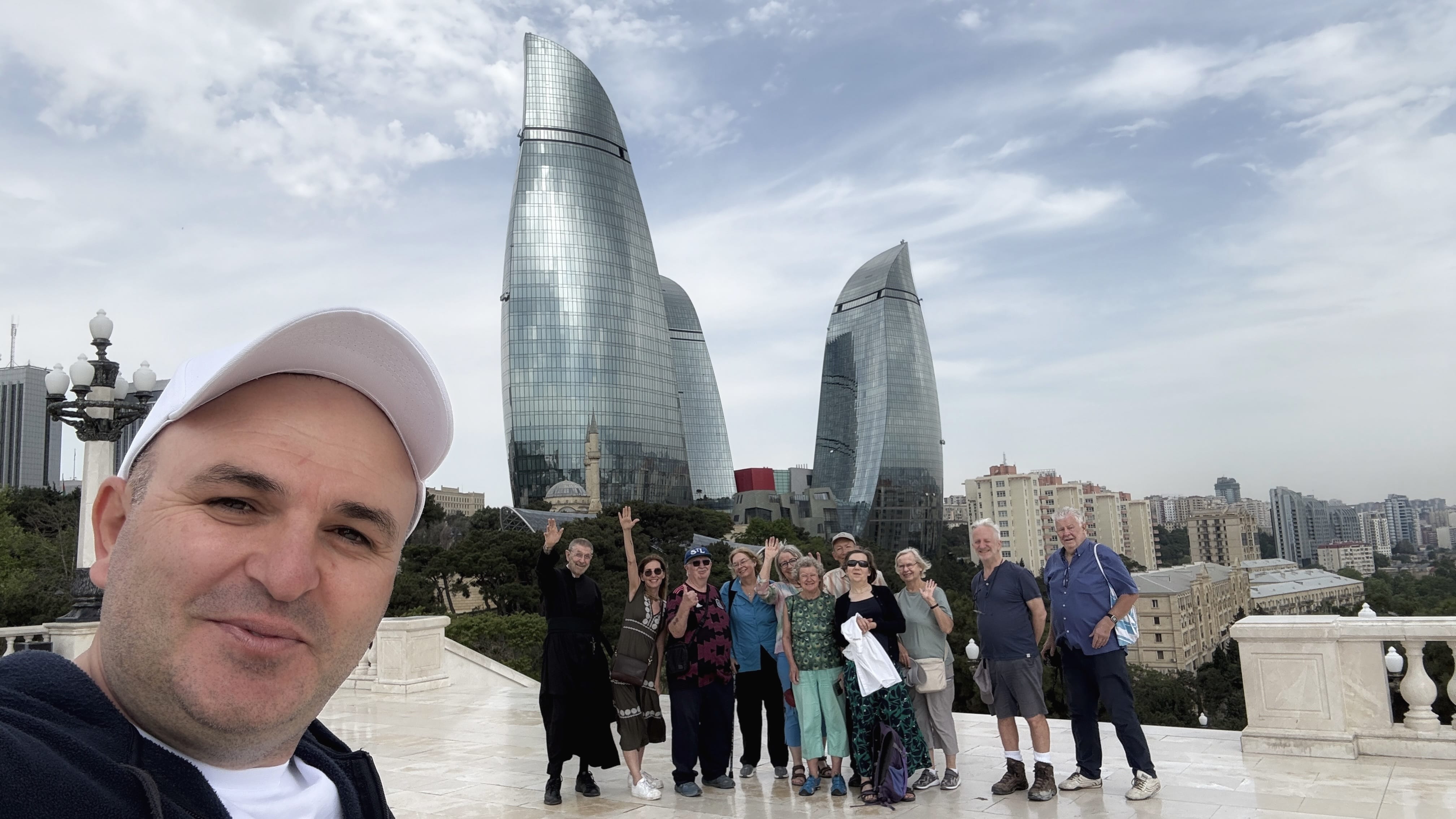 Group of travelers posing with a local guide in front of Baku’s Flame Towers, Azerbaijan — 7 Days in Azerbaijan tour group.