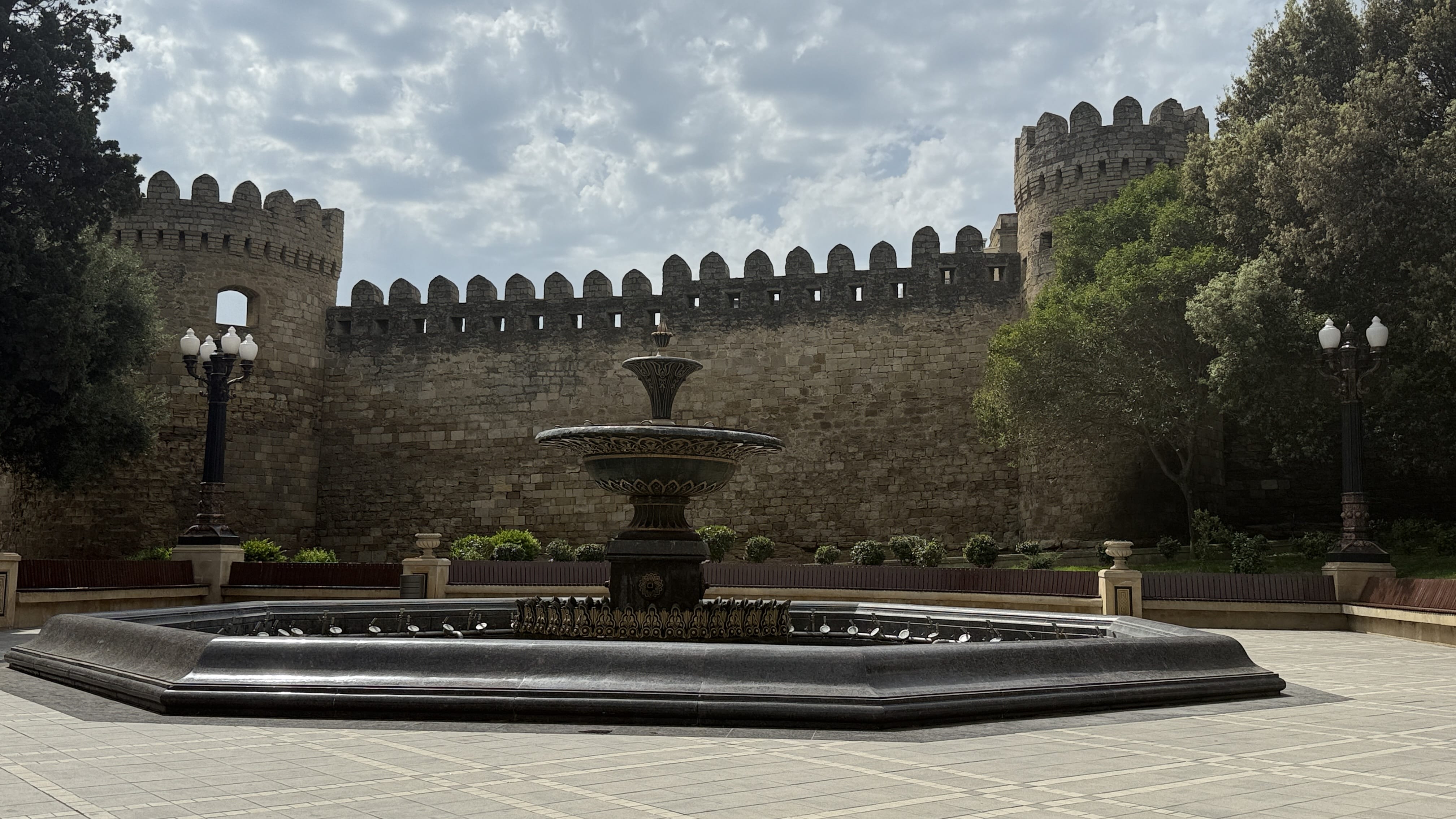 Stone walls of Baku’s Old City (Icherisheher) with a decorative fountain in the foreground — 7 Days in Azerbaijan.
