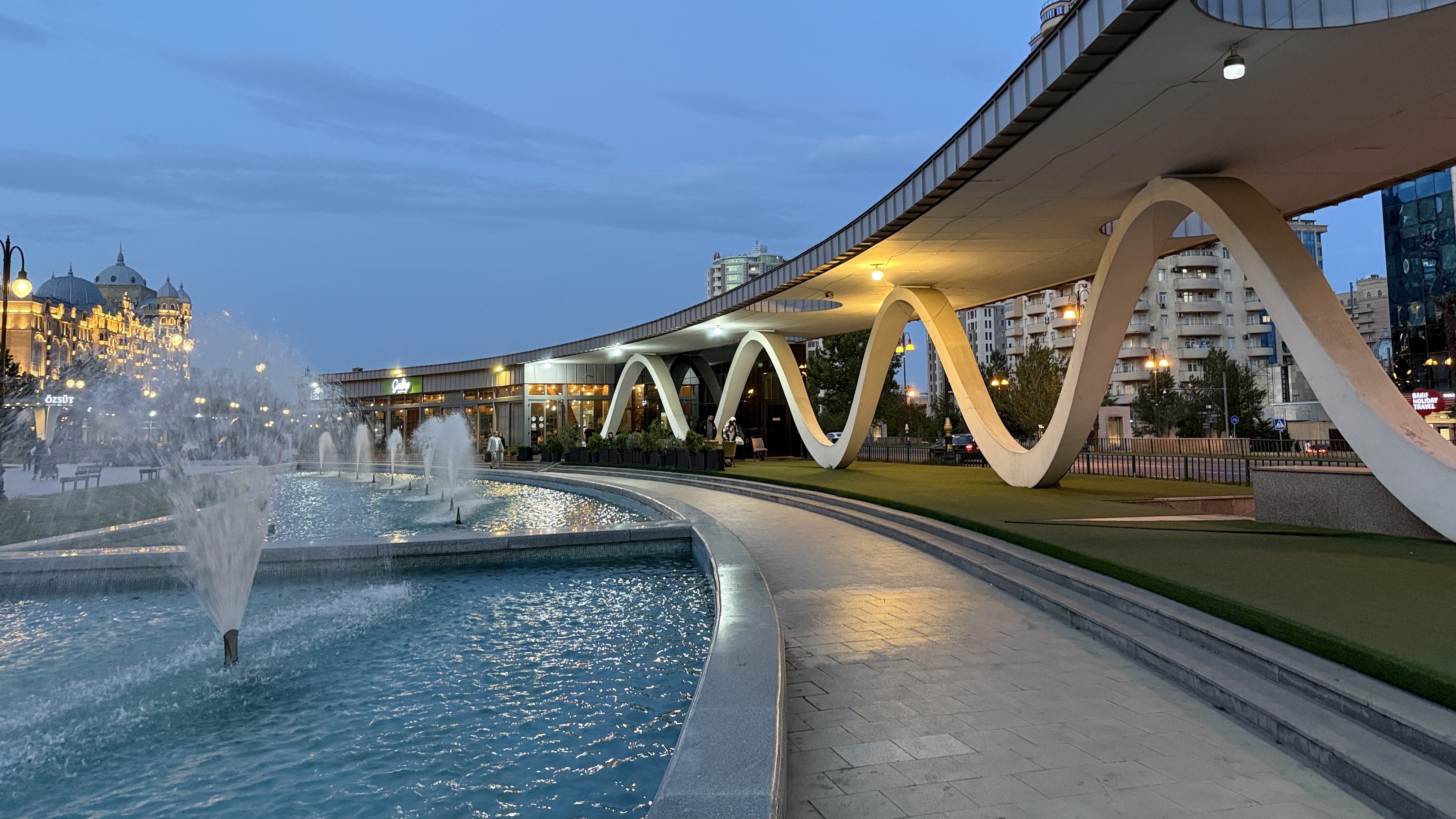 Winter Park Fountain and Walkway Alt text: Evening view of fountains and modern architecture in Winter Park, Baku,