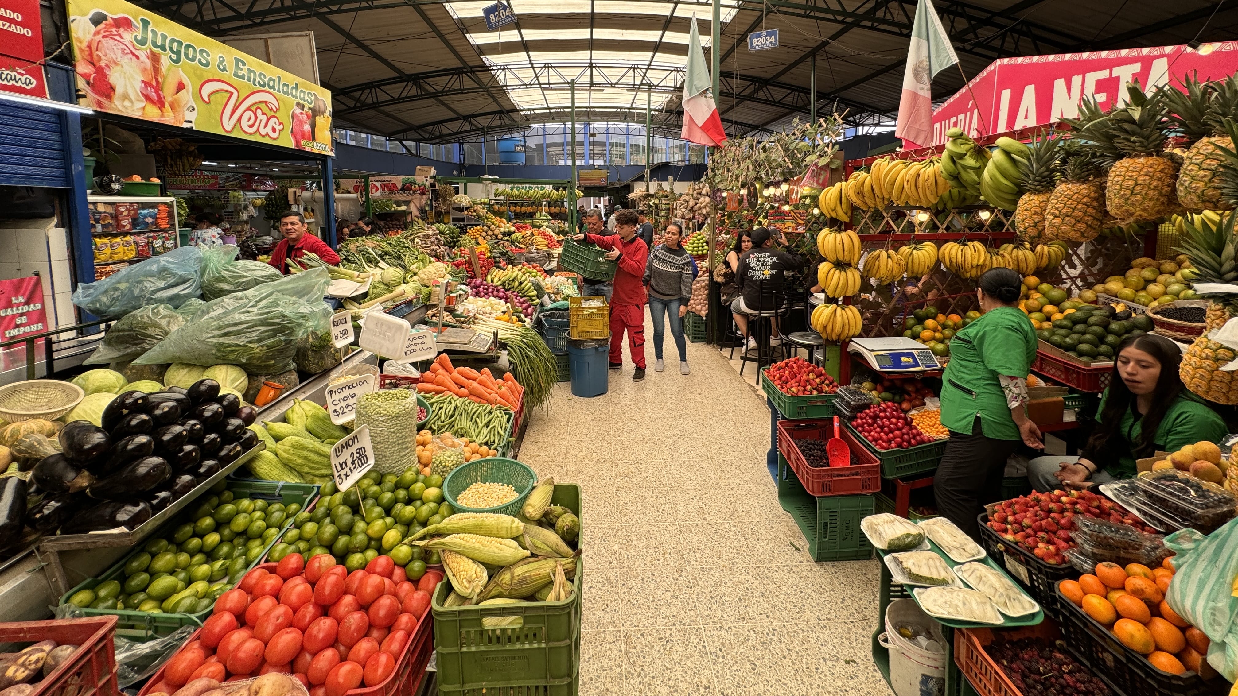 Stalls filled with fruits and vegetables at Paloquemao Market in Bogotá, including pineapples, bananas, and tomatoes. (2 Days in Bogotá)