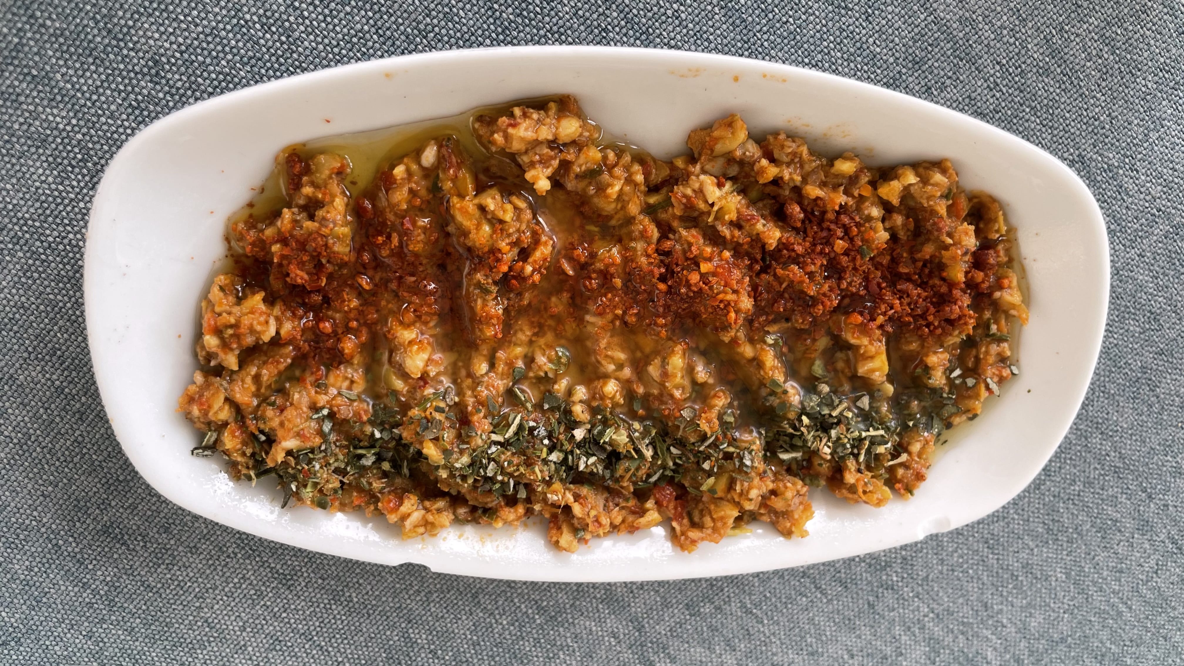 Turkish walnut and pepper dip with herbs and olive oil on a white plate—vegetarian food in Istanbul.