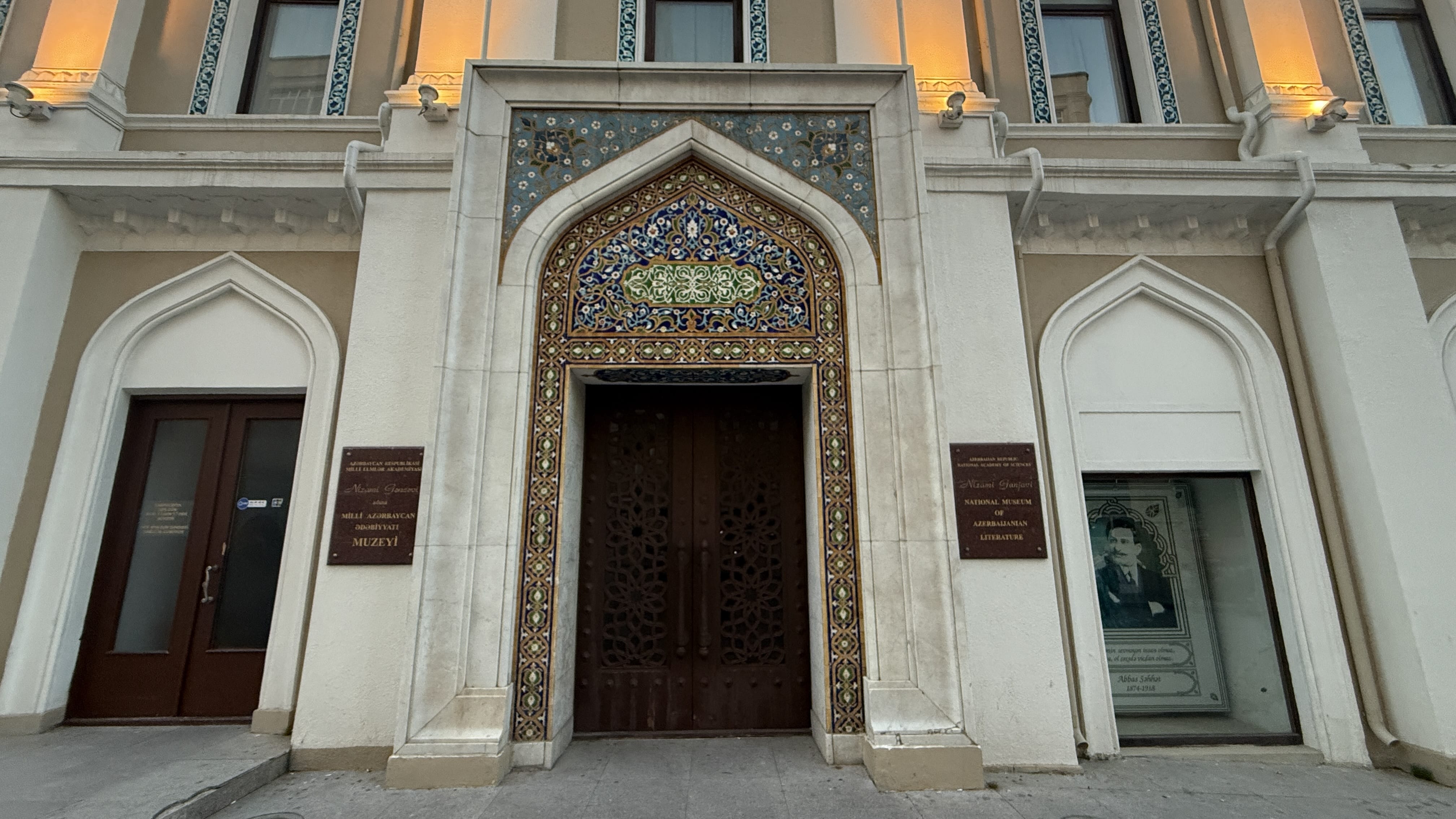 Exterior of the Nizami Museum of Azerbaijani Literature in central Baku, featuring mosaic tilework, arched windows, and statues honoring poet Nizami Ganjavi.