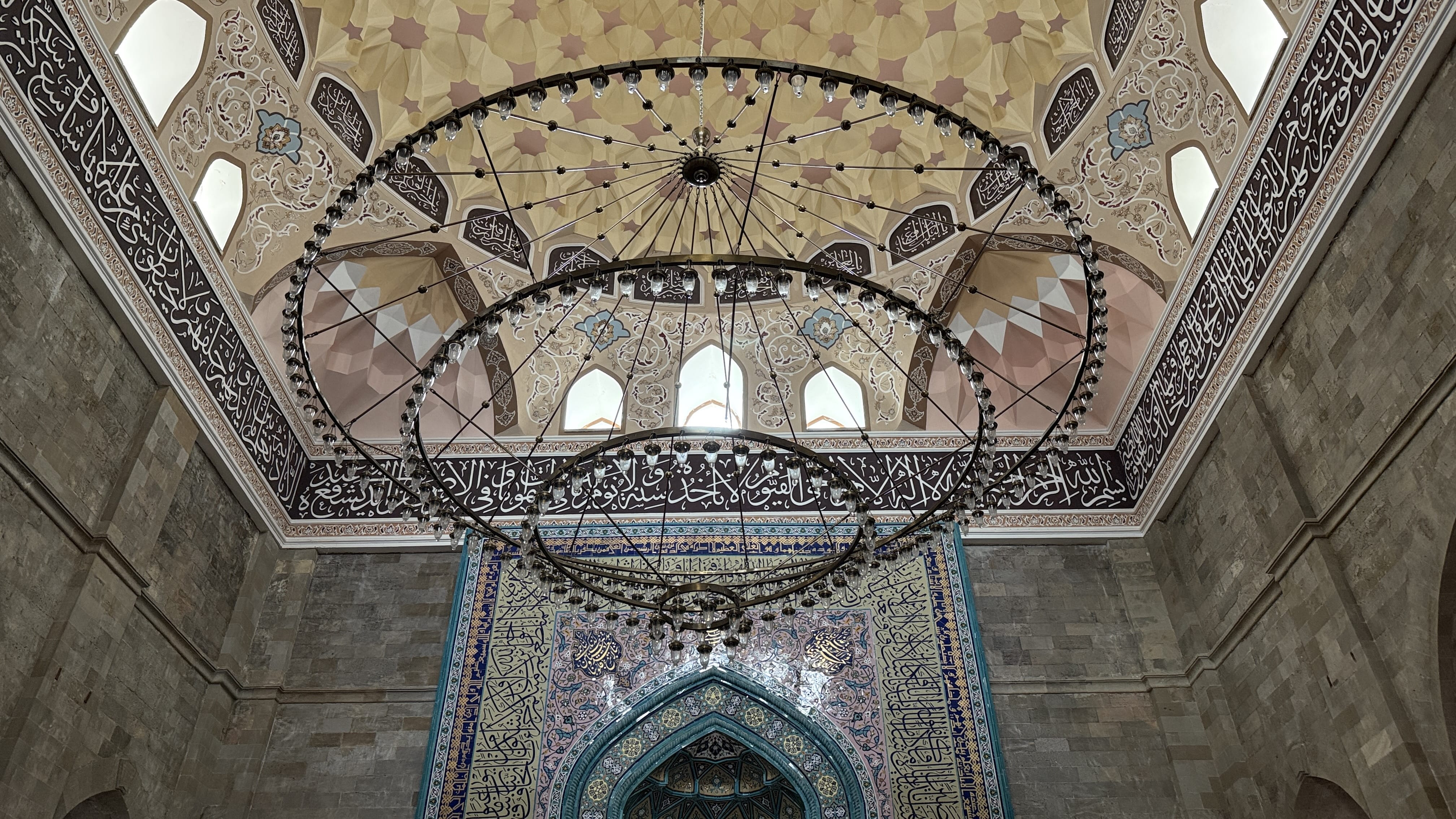 Intricate interior of Juma Mosque in Shamakhi, Azerbaijan, showing colorful geometric ceiling and Arabic calligraphy during 7 Days in Azerbaijan.