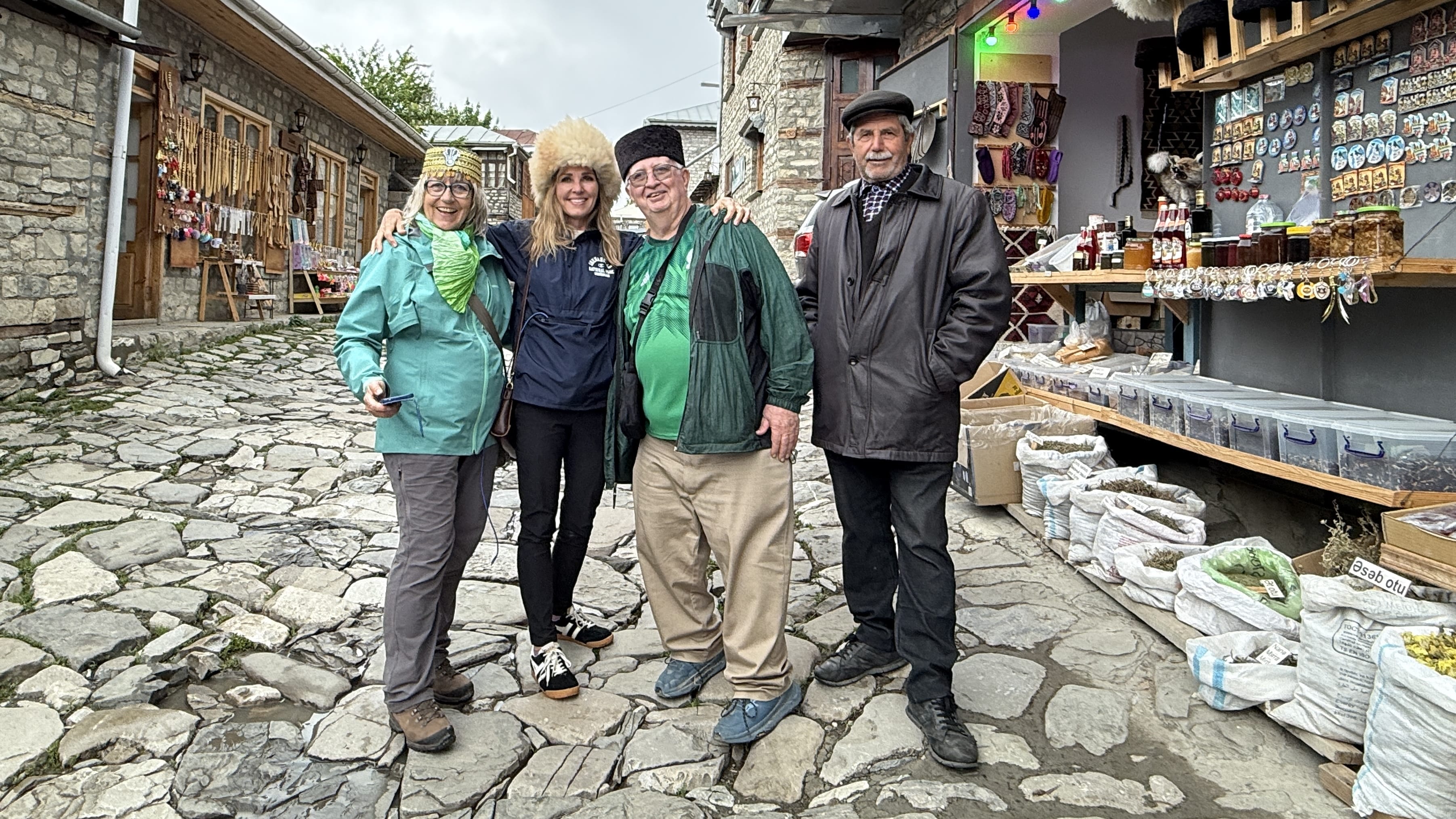 Travelers posing with local vendors in the cobblestone market of Lahic, Azerbaijan, during 7 Days in Azerbaijan.