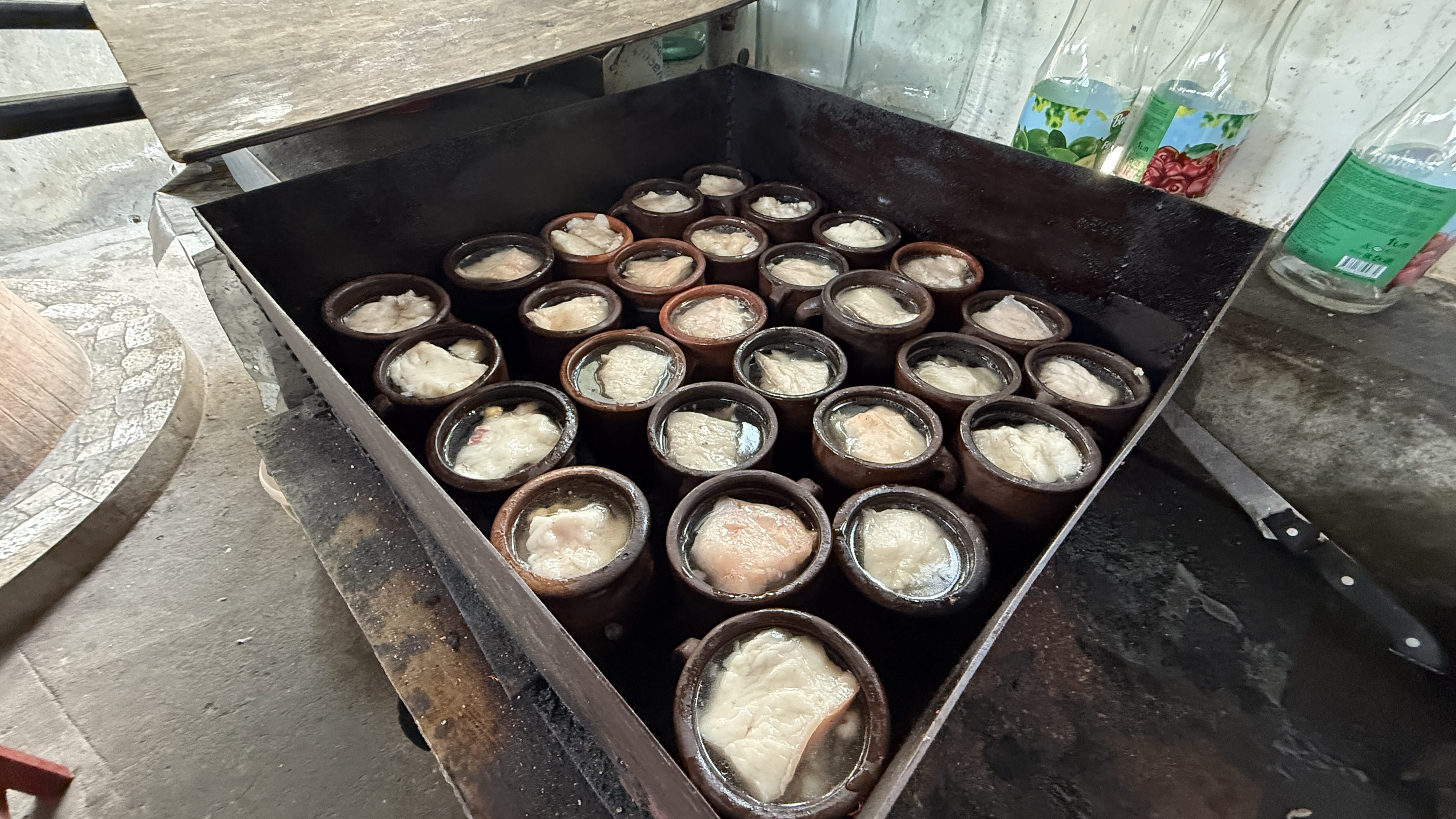 Clay pots filled with lamb, fat, and broth cooking in the traditional Azerbaijani style used for making piti in Sheki, photographed during my 7 Days in Azerbaijan.
