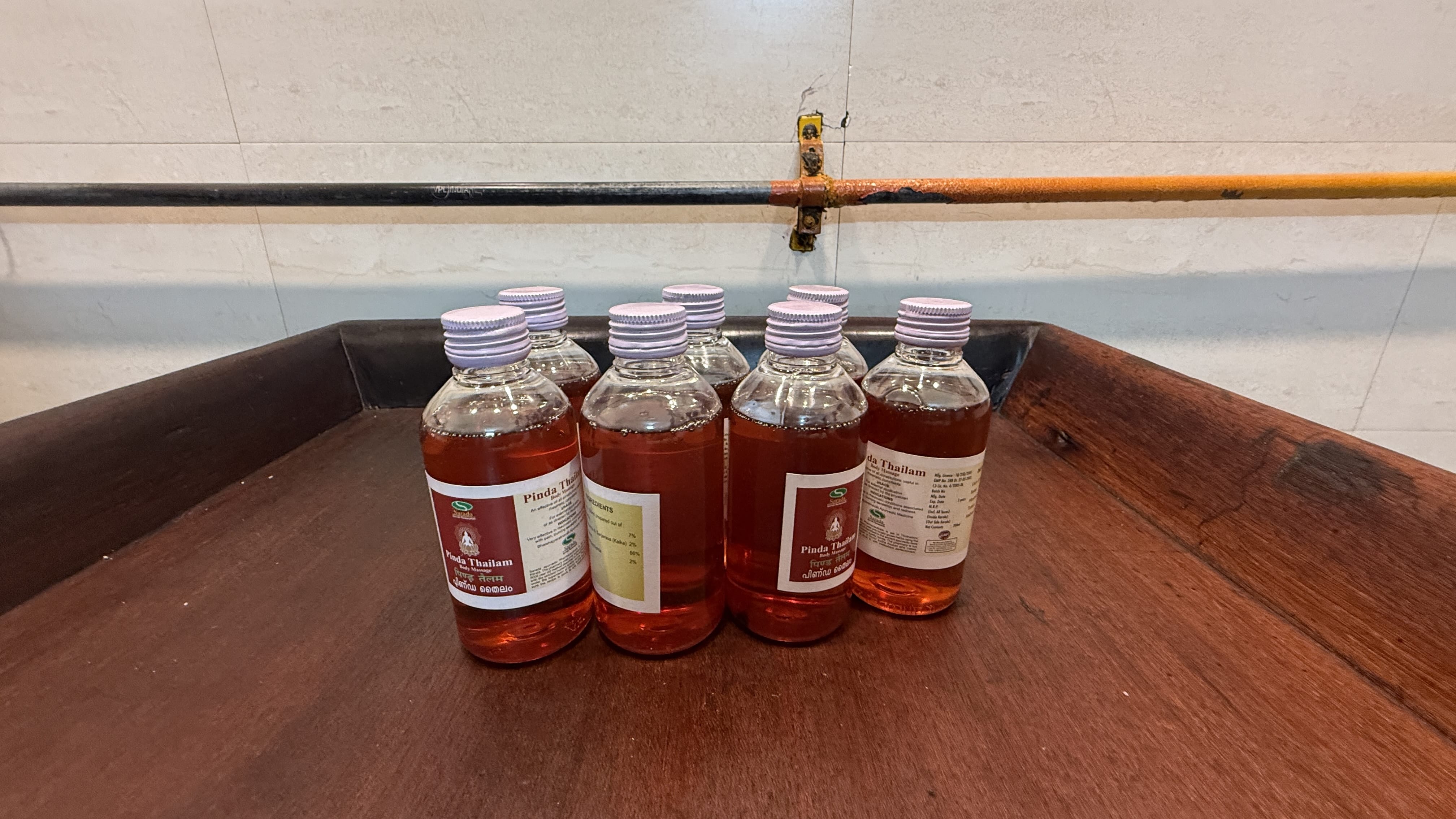 Bottles of Pinda Thailam oil used for the Abhyangam massage at Dr. Sudha’s Ayurveda Kendra in Delhi, showing the traditional reddish Ayurvedic herbal oil.