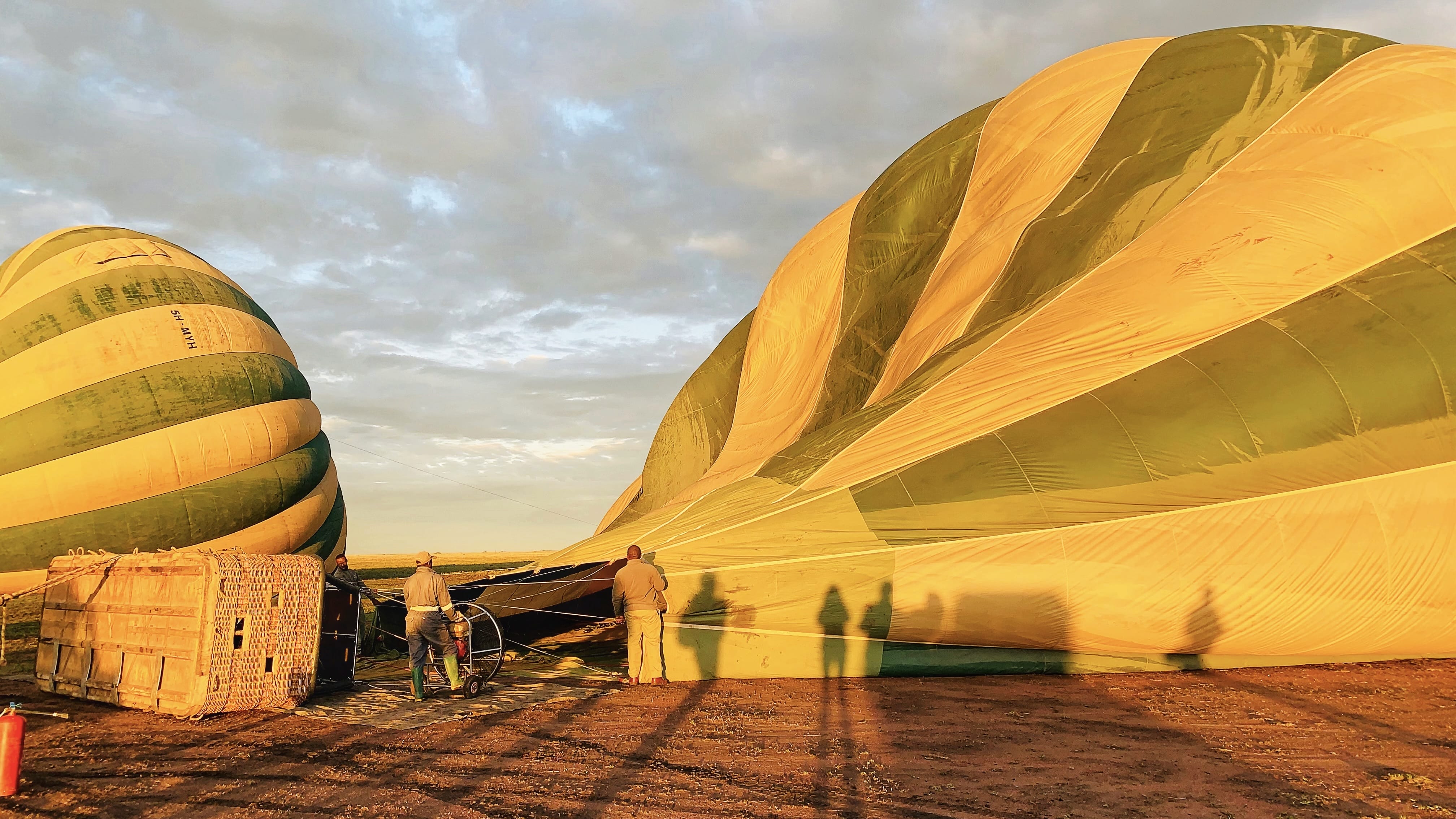 Hot air balloon being inflated at sunrise in Serengeti National Park, Tanzania, before a morning balloon safari
