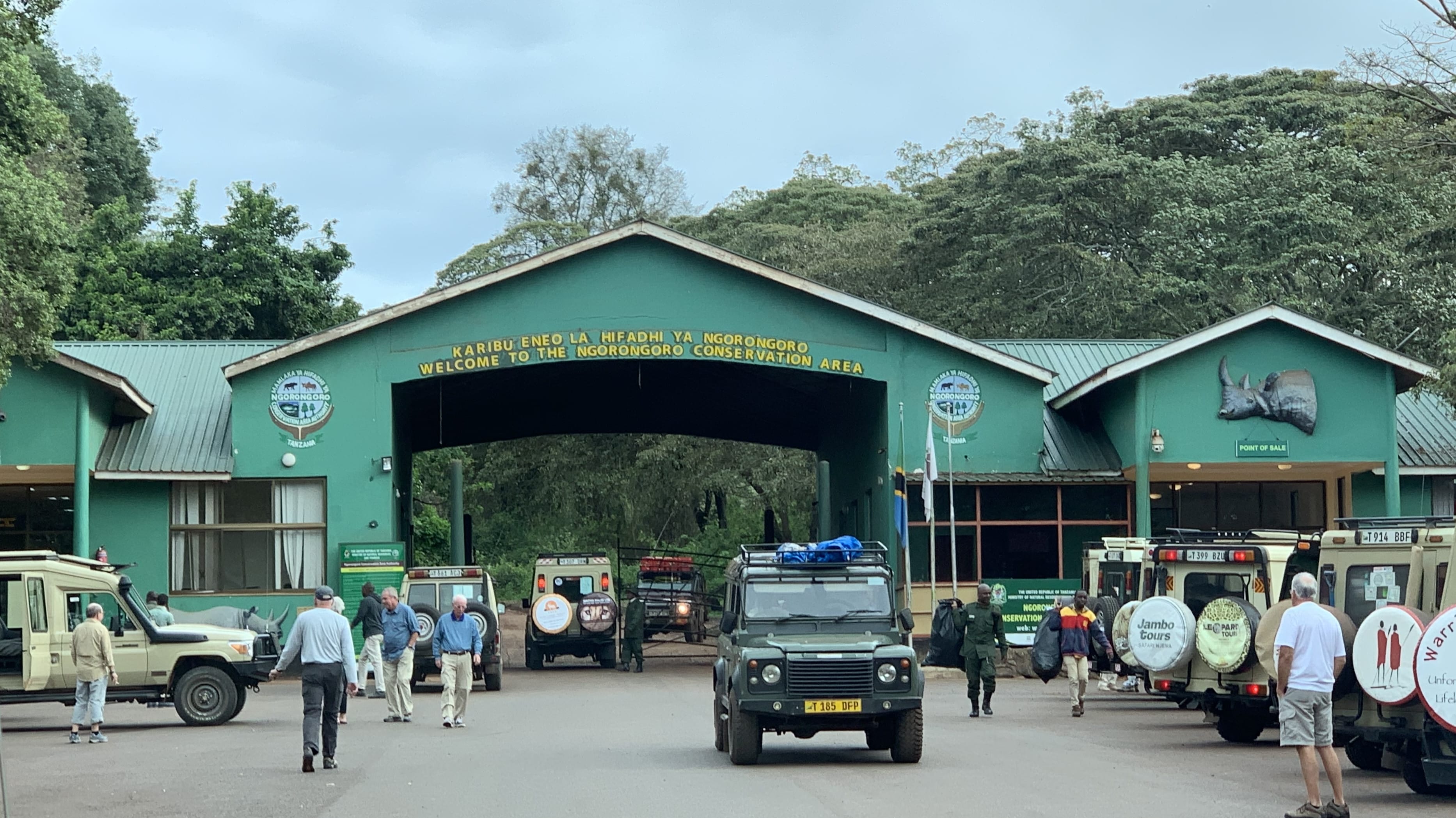 Entrance gate to Ngorongoro Conservation Area with safari vehicles and travelers in Tanzania