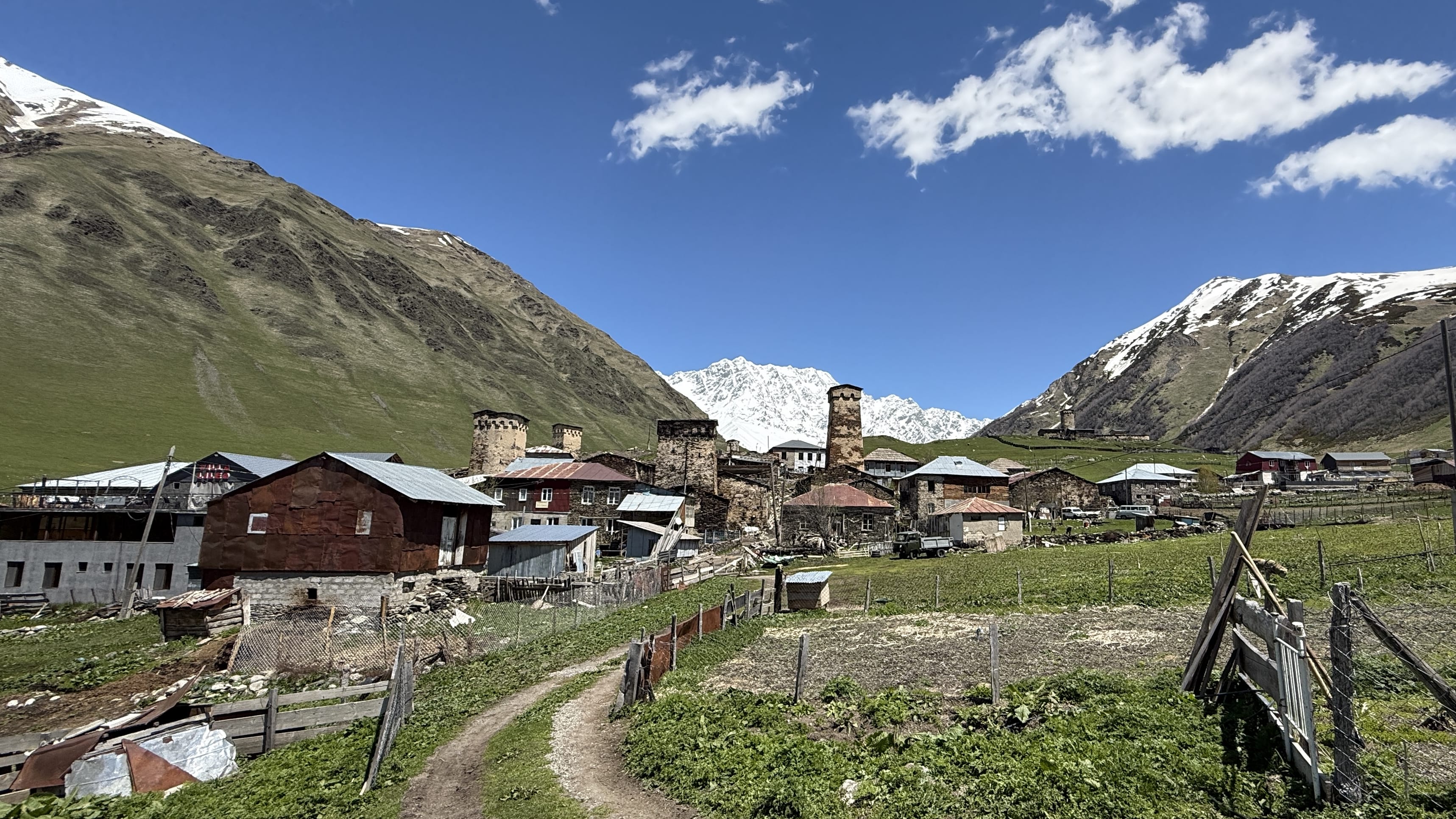 Cluster of stone homes and defensive towers in Ushguli village with Caucasus Mountains in the background