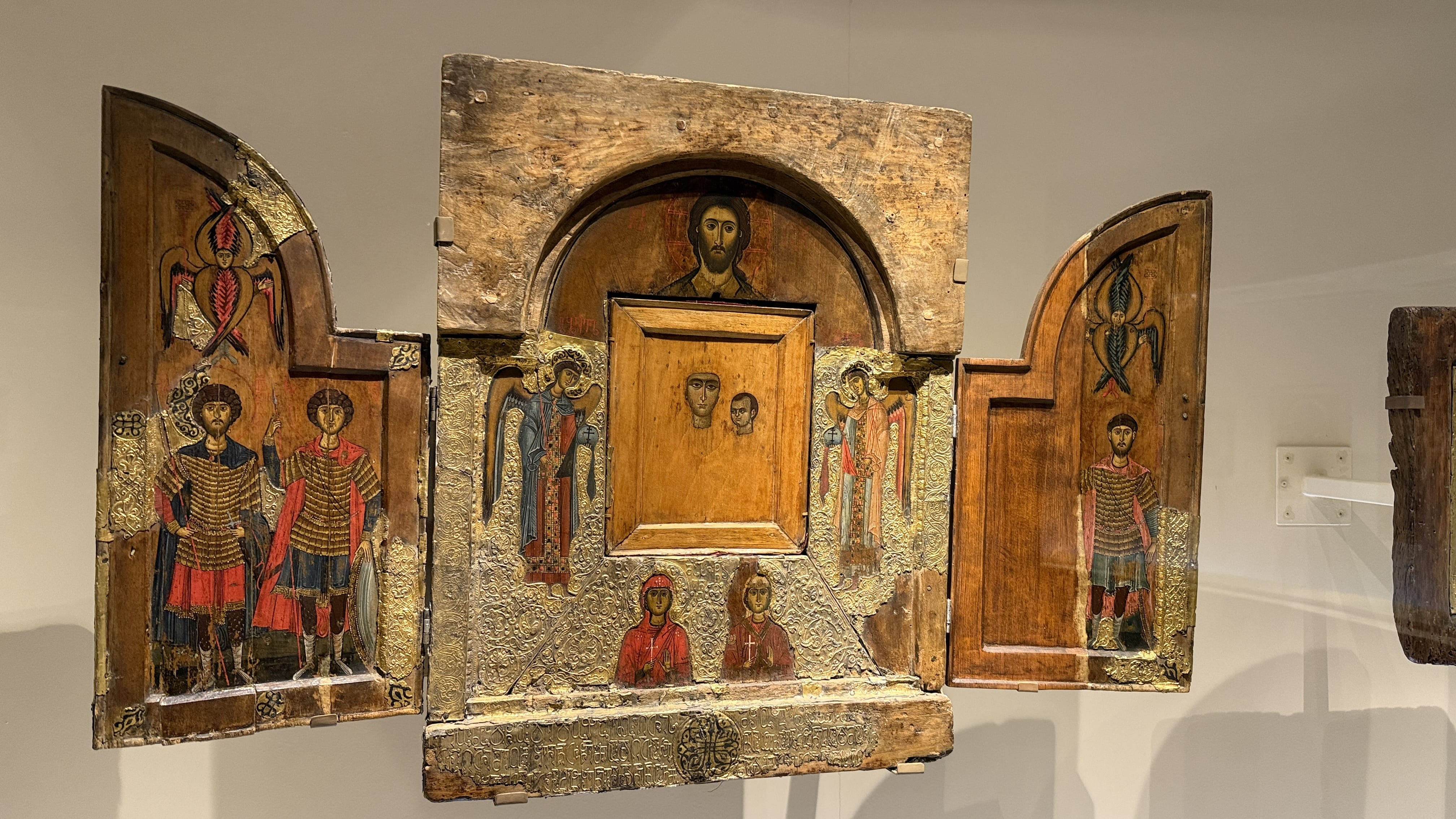 Medieval Georgian triptych icon with painted saints and metal repoussé panels, displayed at the Svaneti History and Ethnographic Museum in Mestia
