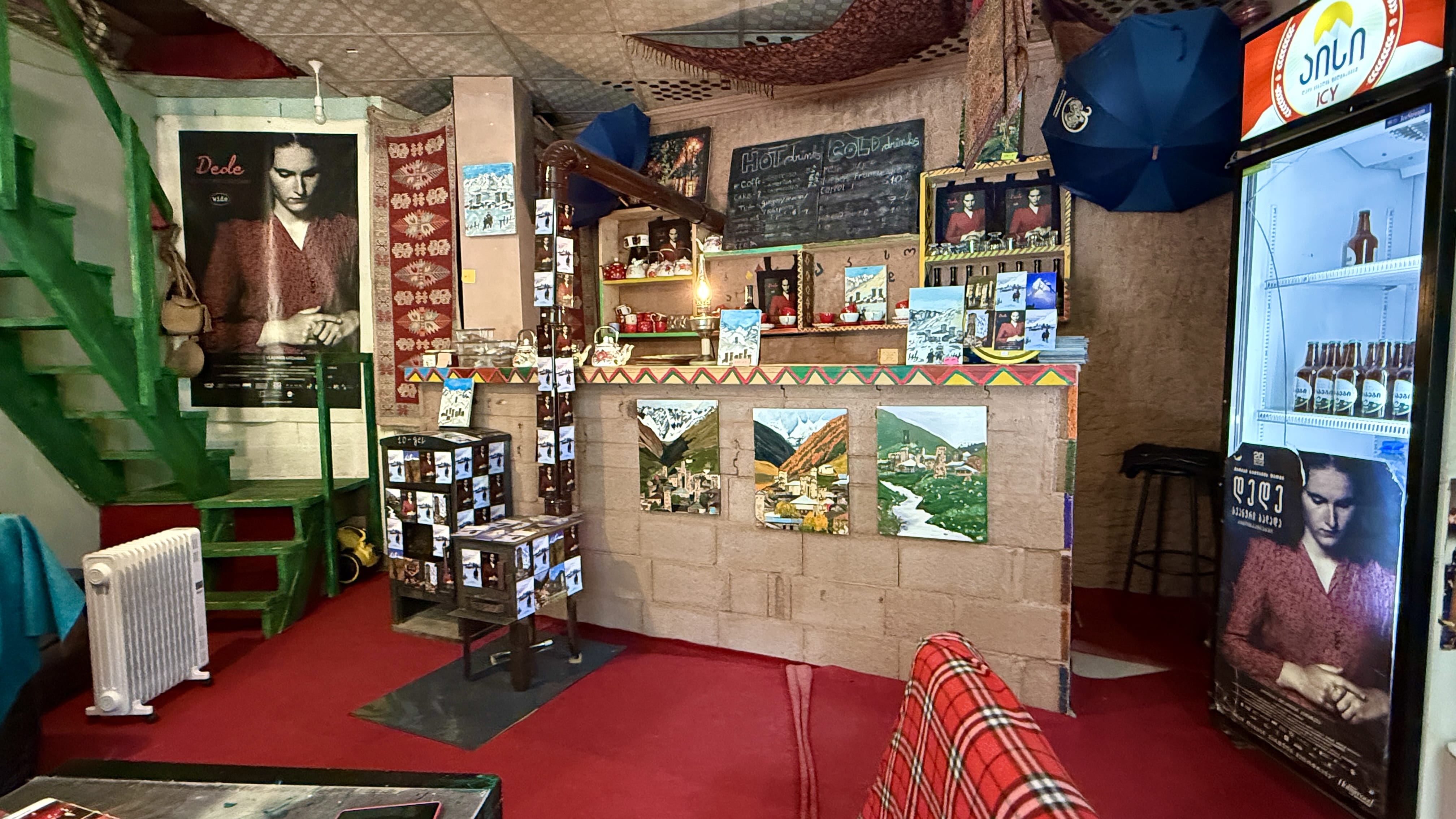 Interior of Dede Cinema in Mestia with cozy counter, posters, souvenirs, and colorful decor in Svaneti, Georgia.