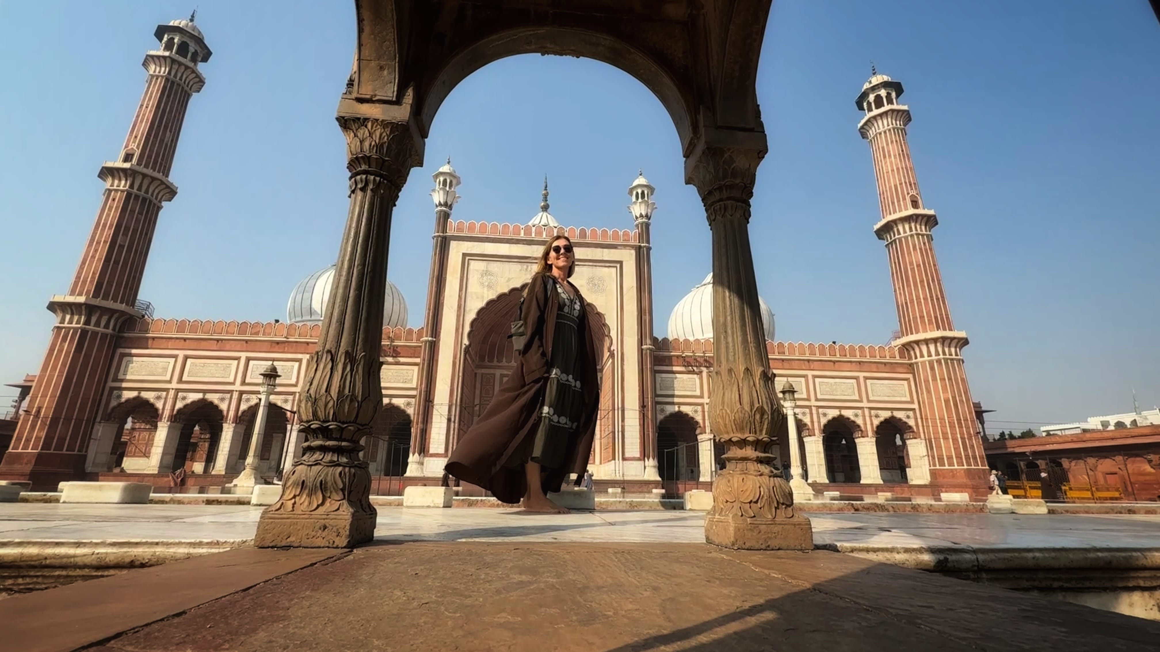 Standing inside Jama Masjid courtyard during my 2 Days in Delhi itinerary, surrounded by Mughal-era arches and tall minarets.