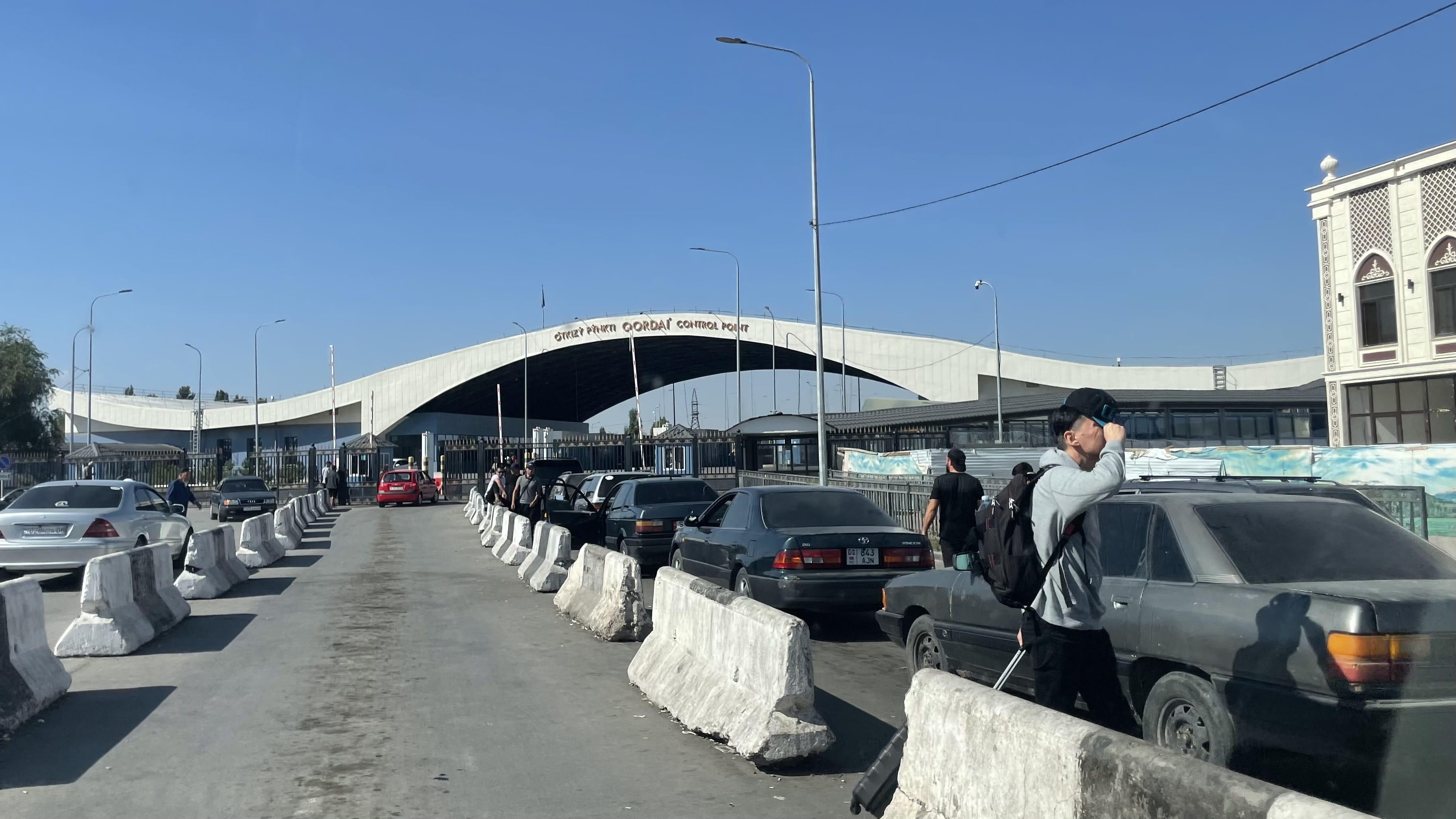 Korday/Ak-Zhol border crossing between Kazakhstan and Kyrgyzstan with cars lined up at the checkpoint during a 7 days in Kyrgyzstan overland road trip.