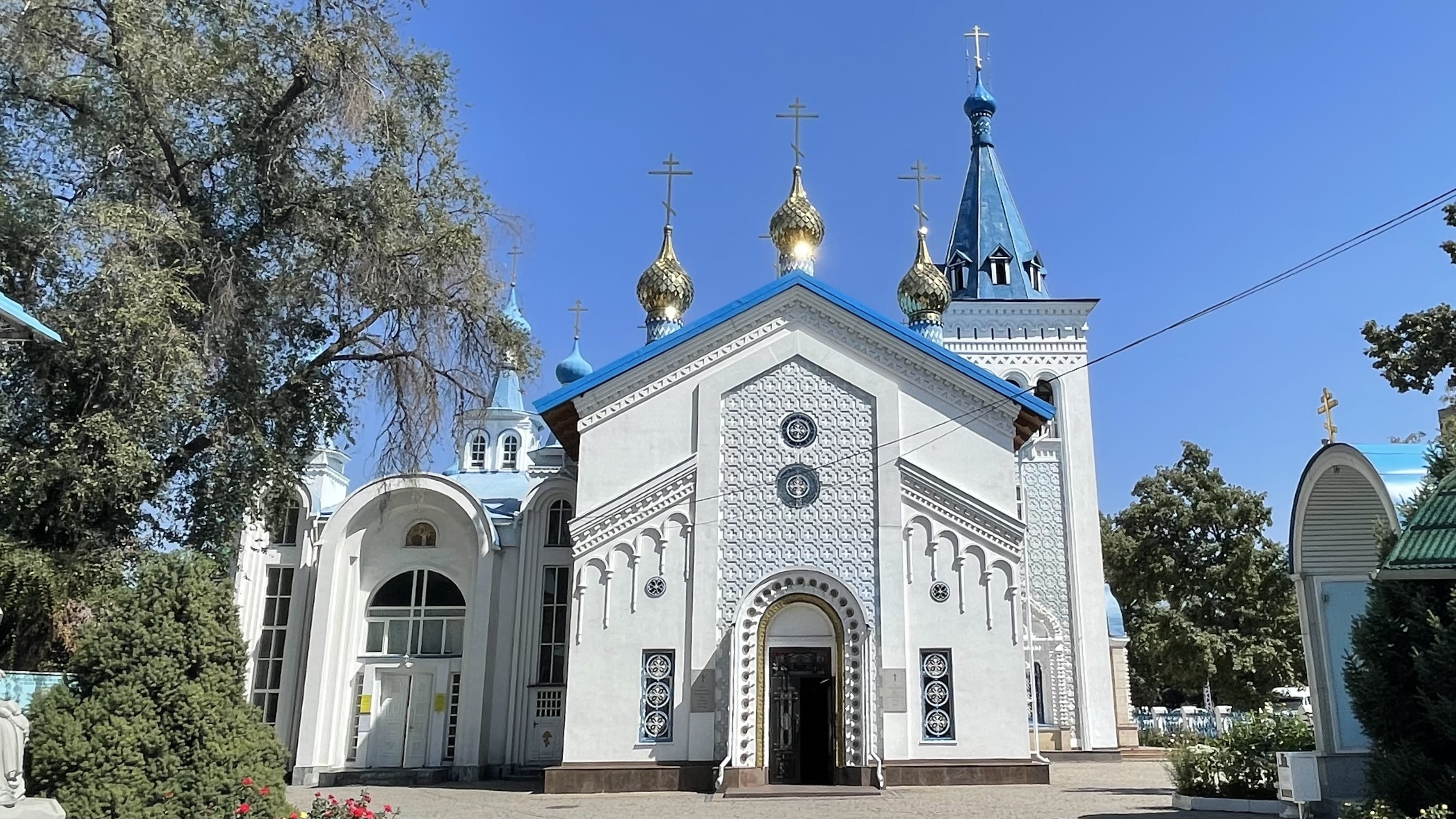Holy Resurrection Orthodox Cathedral in Bishkek, Kyrgyzstan, with blue roofs and gold onion domes under a clear sky (7 days in Kyrgyzstan).