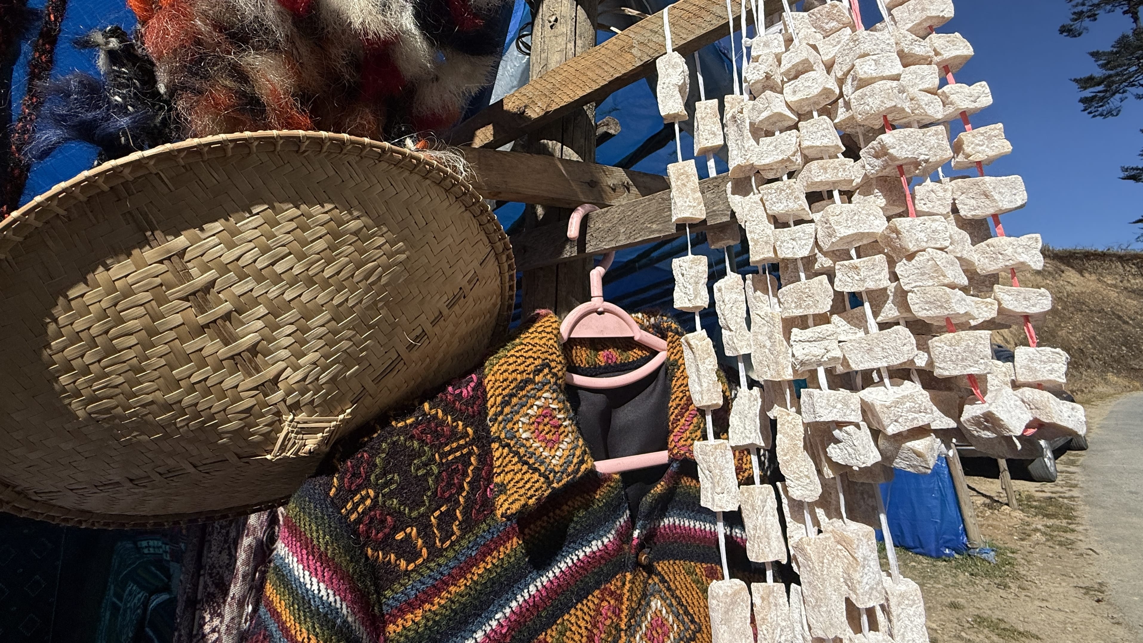 Eating in Bhutan: dried cubes of yak cheese hanging for sale, a common roadside snack in rural Bhutan.