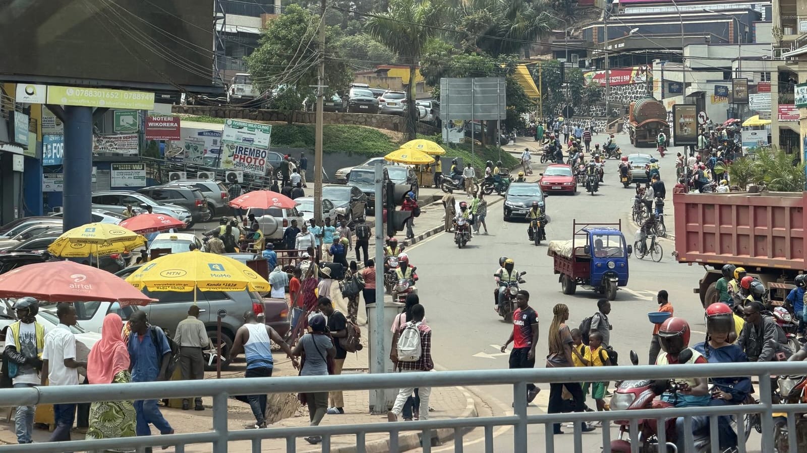A busy street scene in Kigali as we made our way toward Kimironko Market—motorcycle taxis weaving through traffic and vendors set up along the sidewalks.