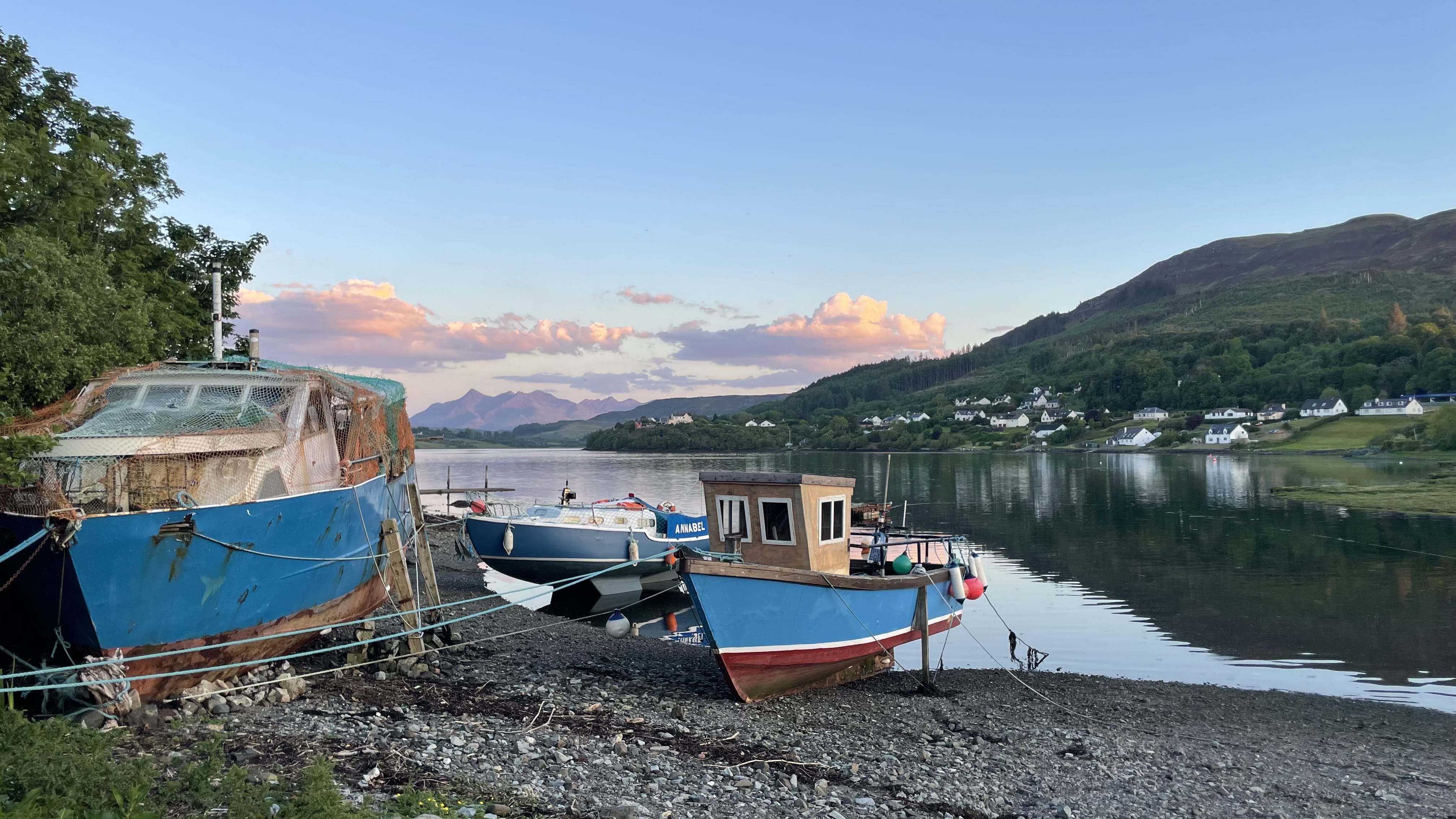 Portree harbor on Isle of Skye Scotland with fishing boats and calm evening light