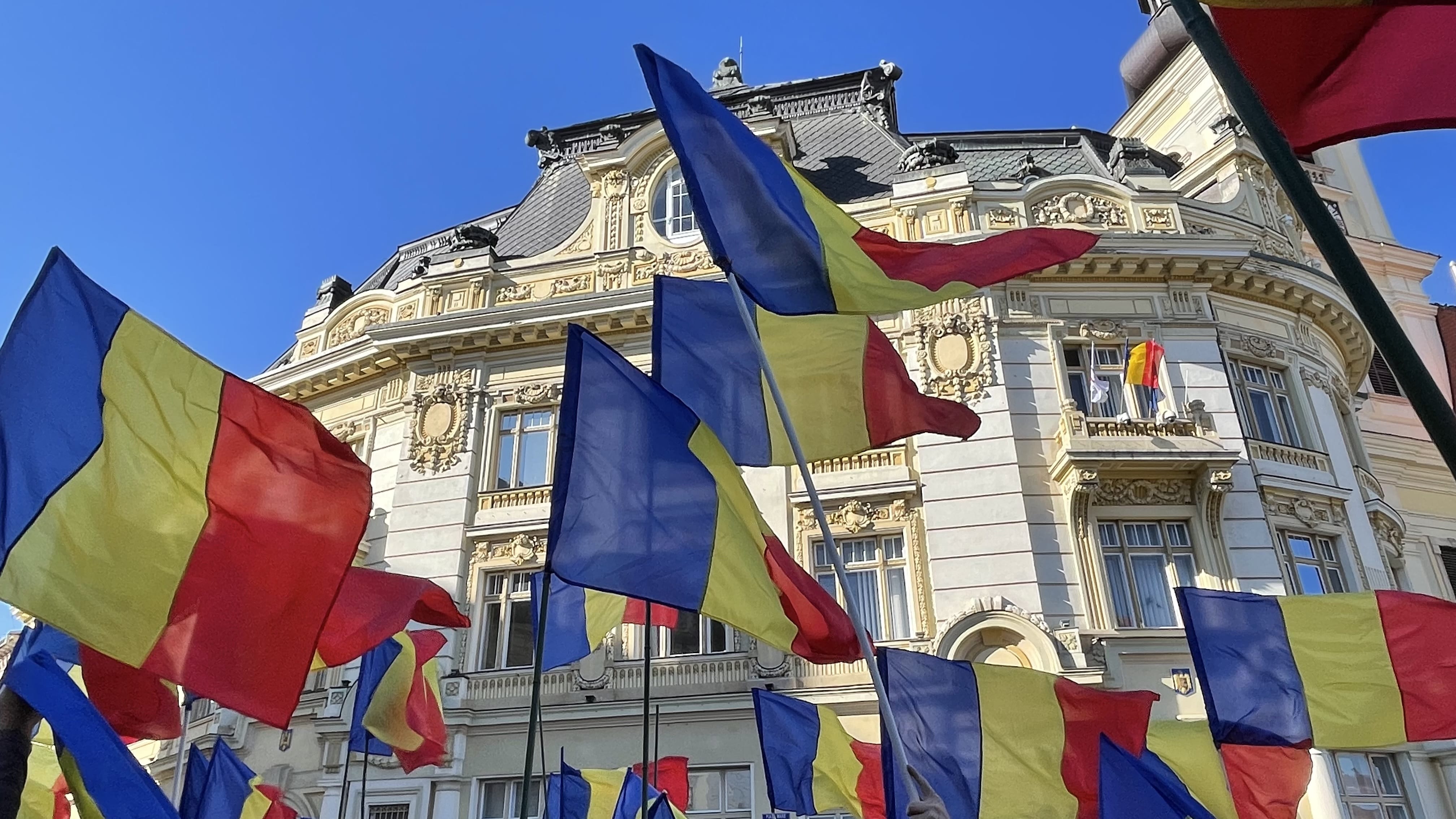 Romanian flags being waved during a public demonstration in Sibiu, Romania.