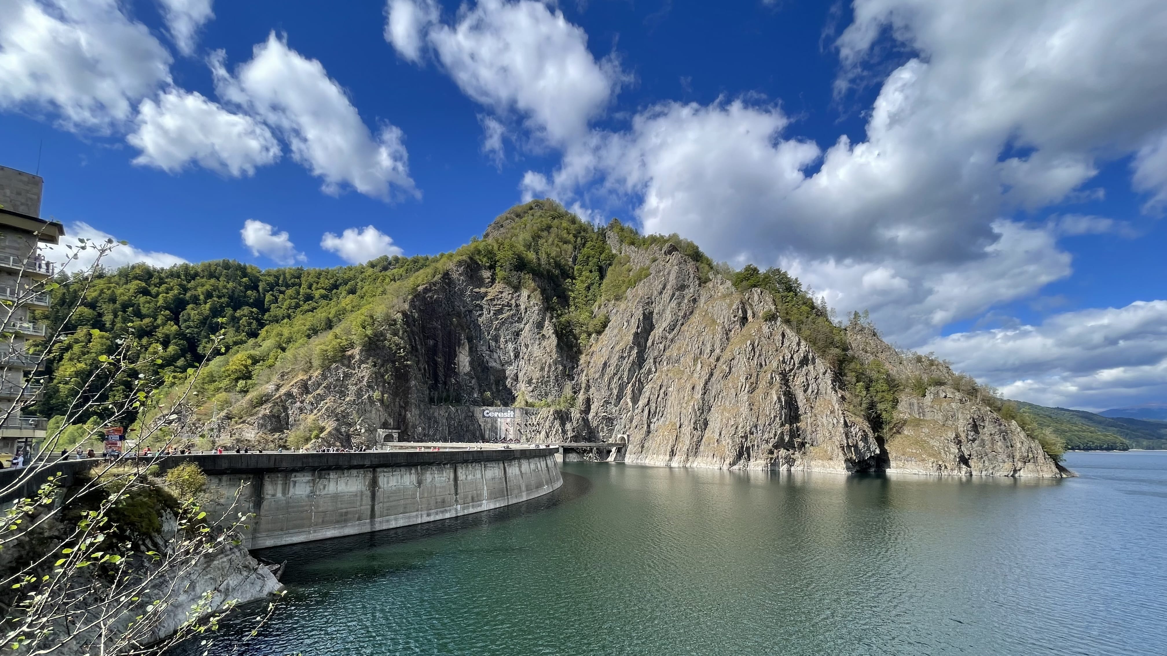 Vidraru Dam and reservoir surrounded by steep rocky cliffs in Romania.